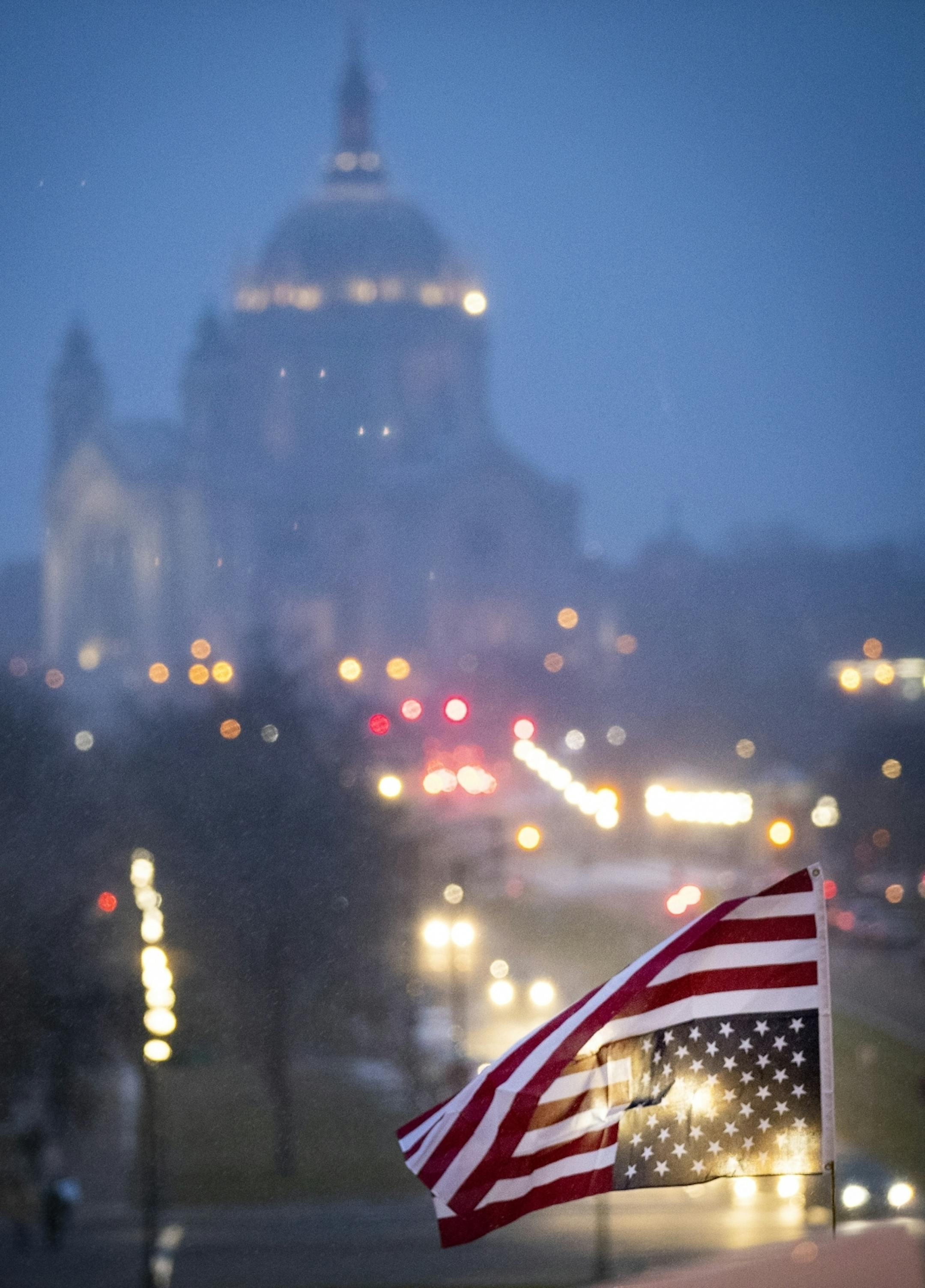 An American flag is flown upside down as the Cathedral of St. Paul in seen in the background at a protest in support of Special Counsel Robert Mueller's investigation.