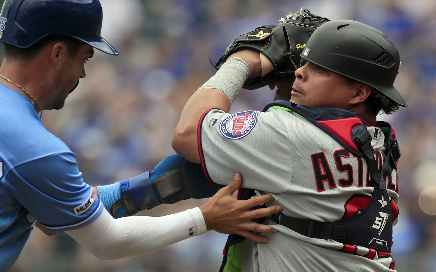 Kansas City Royals' Whit Merrifield, left, is tagged out by Minnesota Twins catcher Willians Astudillo, right, during the first inning of a baseball game at Kauffman Stadium in Kansas City, Mo., Saturday, June 22, 2019. (AP Photo/Orlin Wagner)