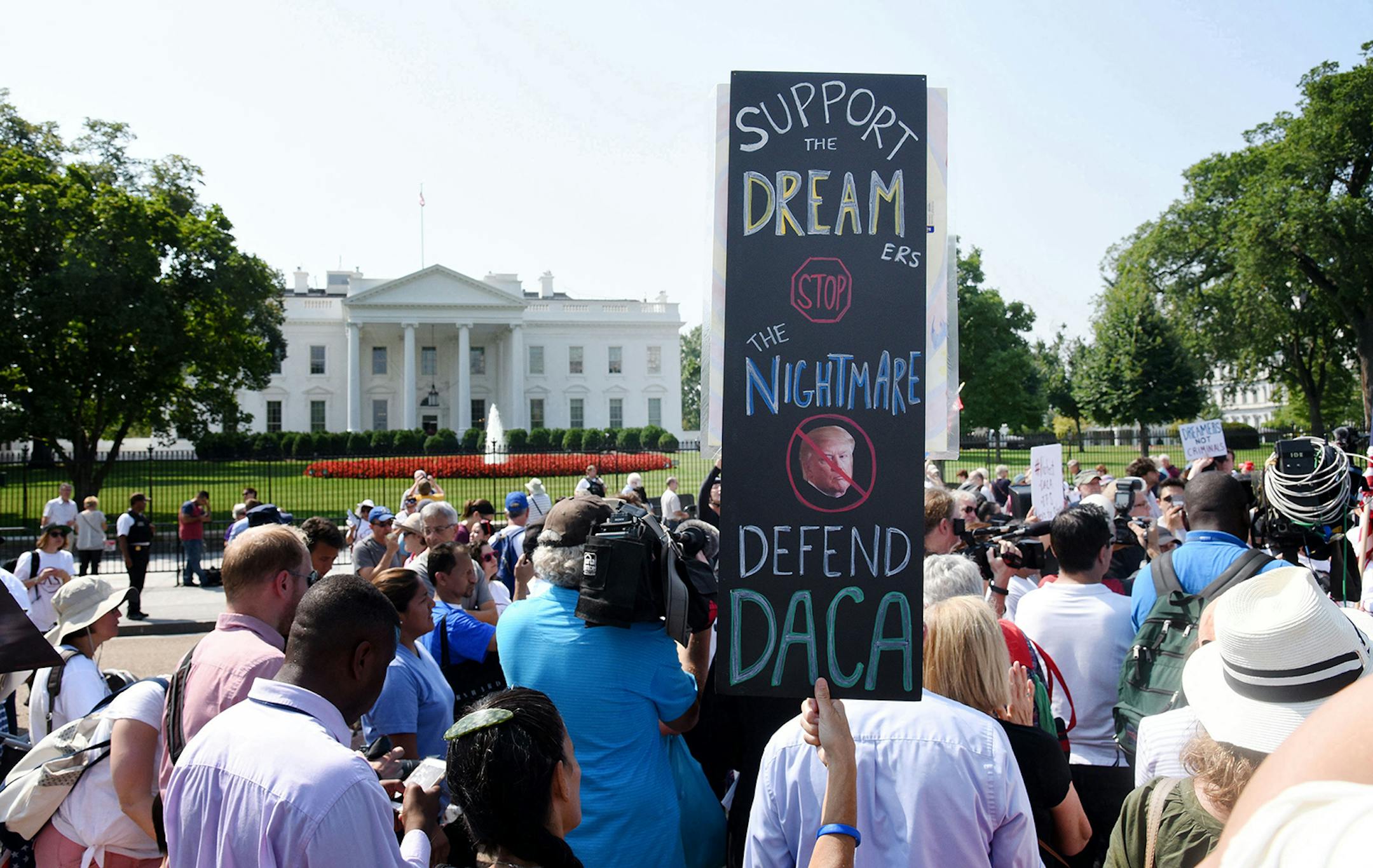 Protesters hold up signs during a rally supporting Deferred Action for Childhood Arrivals, or DACA, outside the White House on Sept. 5, 2017.