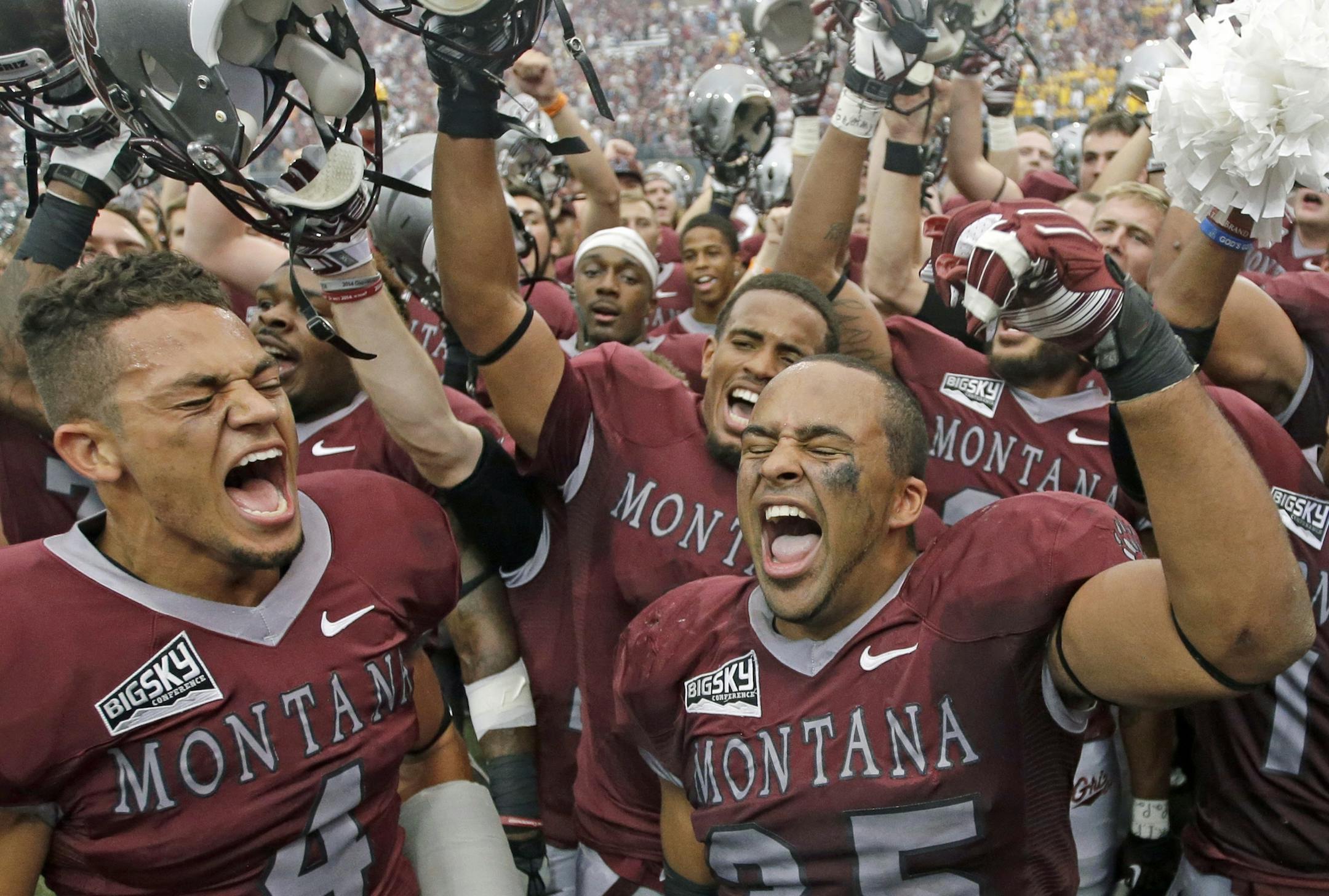 Montana's Chris Parker (4) and Kendrick Van Ackeren (35) celebrate with teammates after their NCAA college football game against North Dakota State Saturday, Aug. 29, 2015, in Missoula, Mont. Montana won 38-35. (AP Photo/Rick Bowmer)