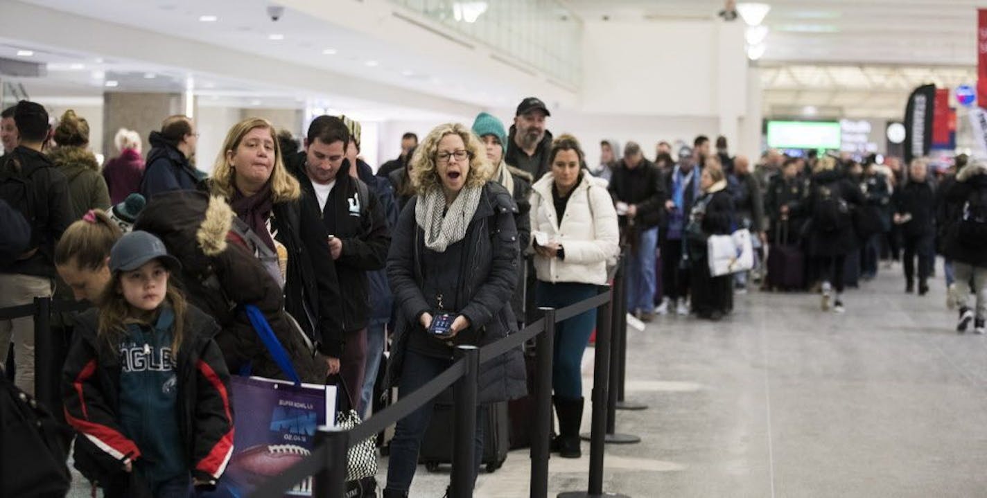 Passengers, some of them still sleepy, wait in the security line at Terminal 1 at MSP Monday morning.