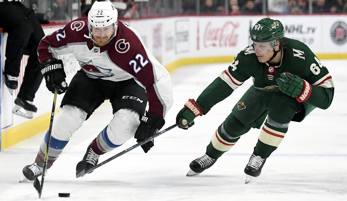 Colorado Avalanche's Colin Wilson (22) skates past Minnesota Wild's Mikael Granlund (64), of Finland, during the second period of an NHL hockey game Saturday, Oct. 27, 2018, in St. Paul, Minn. (AP Photo/Hannah Foslien)