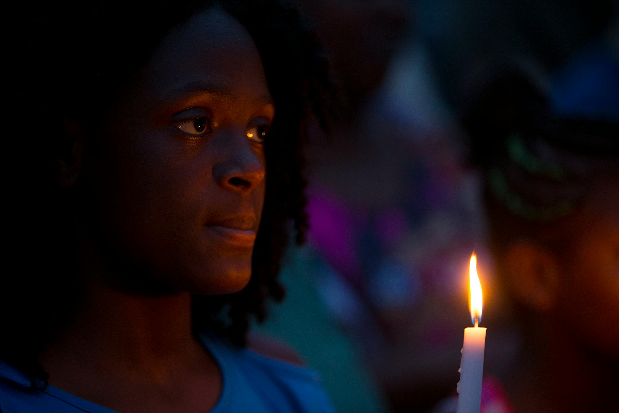 Emahnie Griffin holds a candle as she listens to speakers share their stories at the vigil. ] ALEX KORMANN � alex.kormann@startribune.com Dozens of local community members, family of Thurman Belvins and activists gathered at the corner of 48th street and Camden Ave on Sunday evening for a candle lit vigil to remember the life of Belvins who died Saturday. Belvins was shot by police starting on that same corner Saturday afternoon. Community members expressed anger, frustration, pain and sadness.
