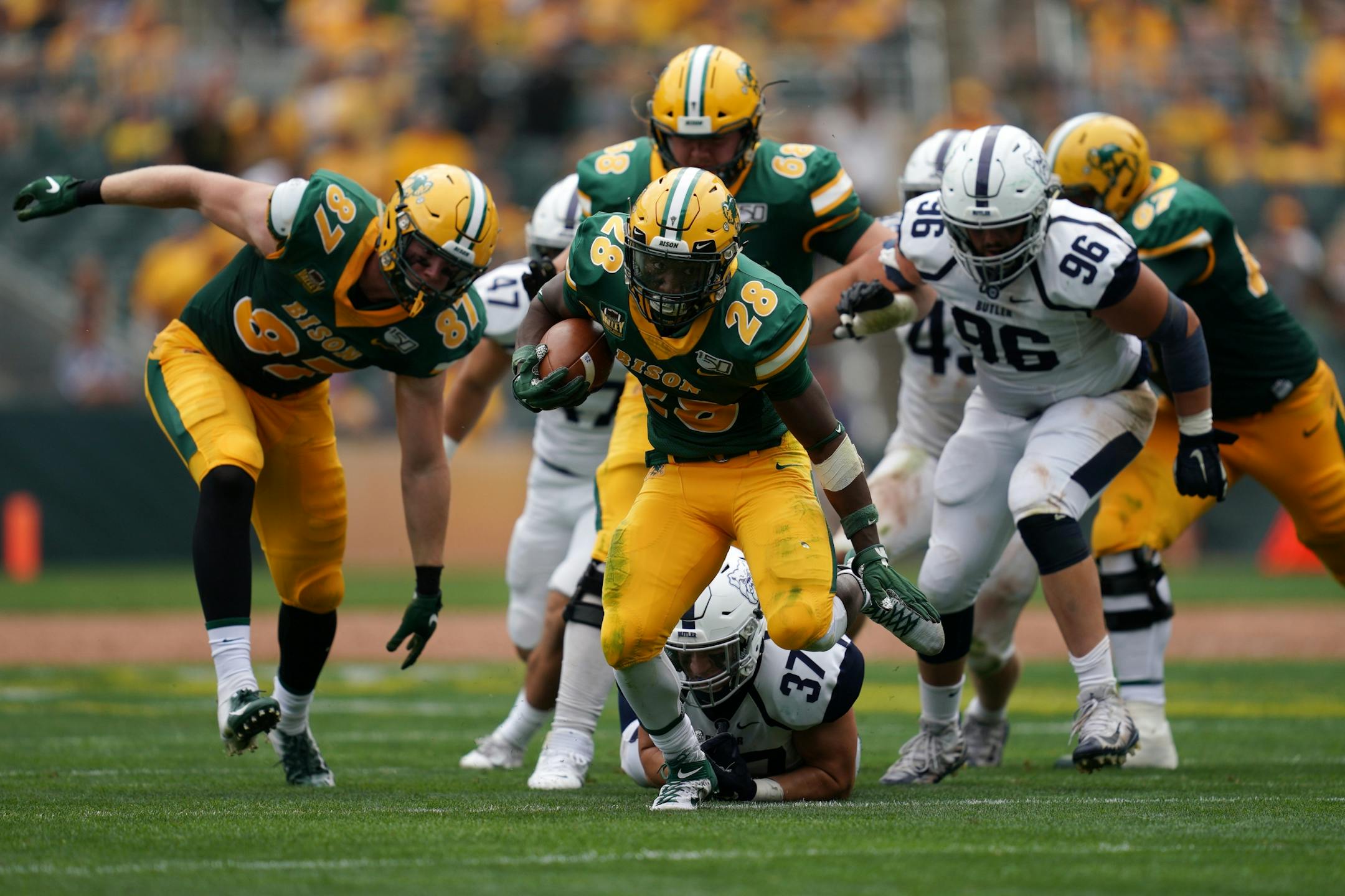 North Dakota State Bison running back Ty Brooks (28) sprinted down the field with the ball after avoiding the tackle by Butler Bulldogs defensive end Justin Markus (37) in the first half.