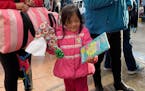Sofia Nhanelii, 4, from Oaxaca, Mexico, opens a coloring book on Christmas Eve while her family waits in Tijuana for their turn to make an initial asy