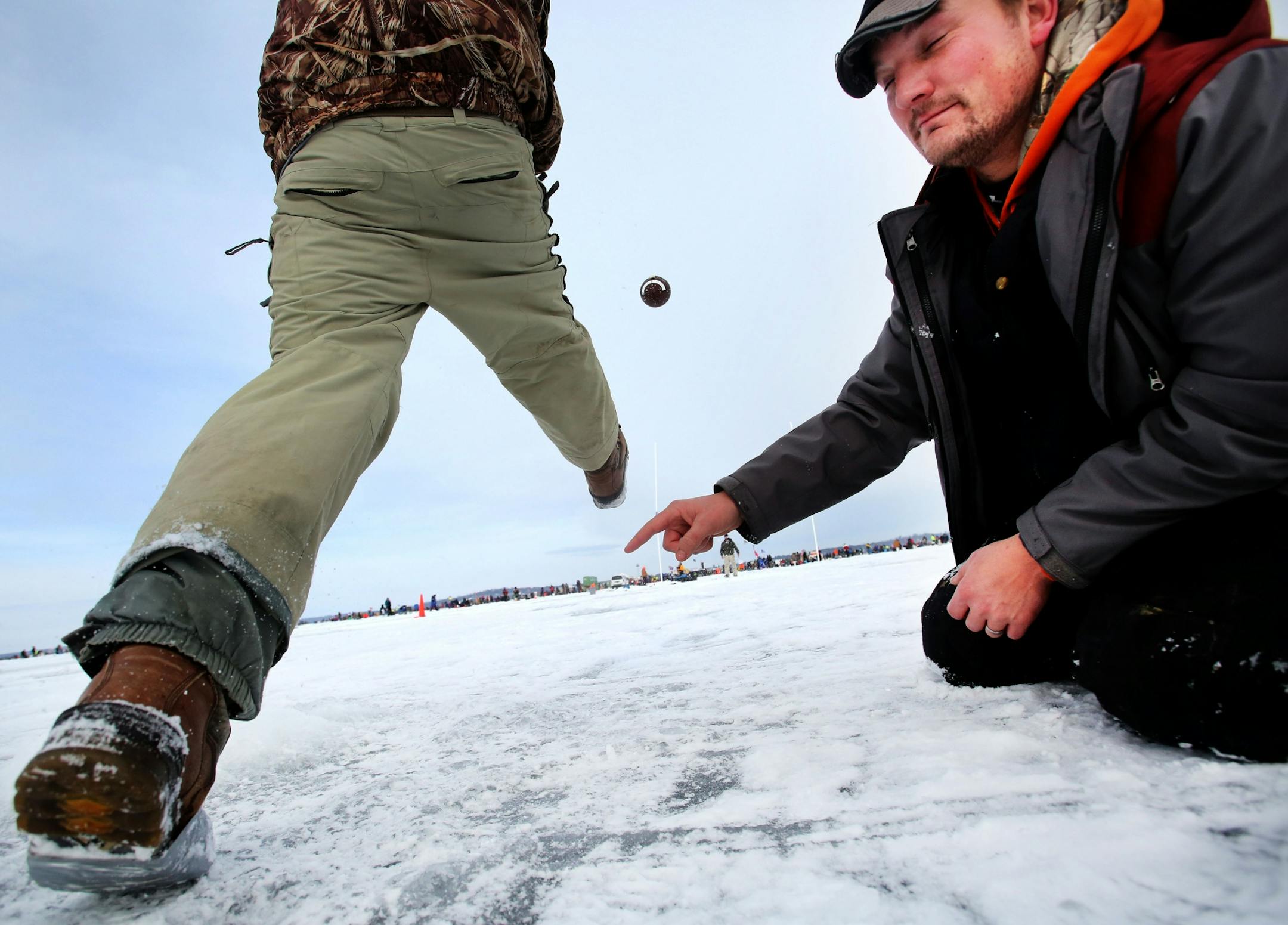 Matt Wagner of Perham, MN, held a football for Pete Guck as a group of fishing contests from Perham tried to make a 27 yard field goal on Hole in the Day Bay of Gull Lake prior to the annual Ice Fishing Extravaganza Saturday, Feb. 6, 2016, in Brainerd, MN. The group from Perham was trying to match the distance of the Vikings' Blair Walsh field goal miss during their loss to the Seattle Seahawks during playoff action. Guck, who made a field goal out of PVC, was the only one to make a field goal.
