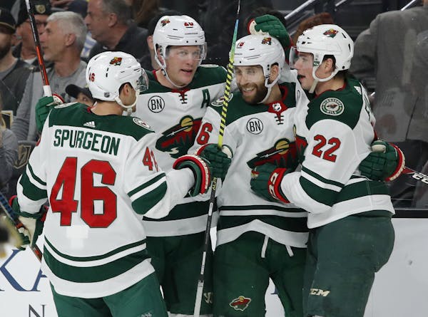Minnesota Wild players celebrate after Jason Zucker, second from right, scored against the Vegas Golden Knights during the first period of an NHL hock