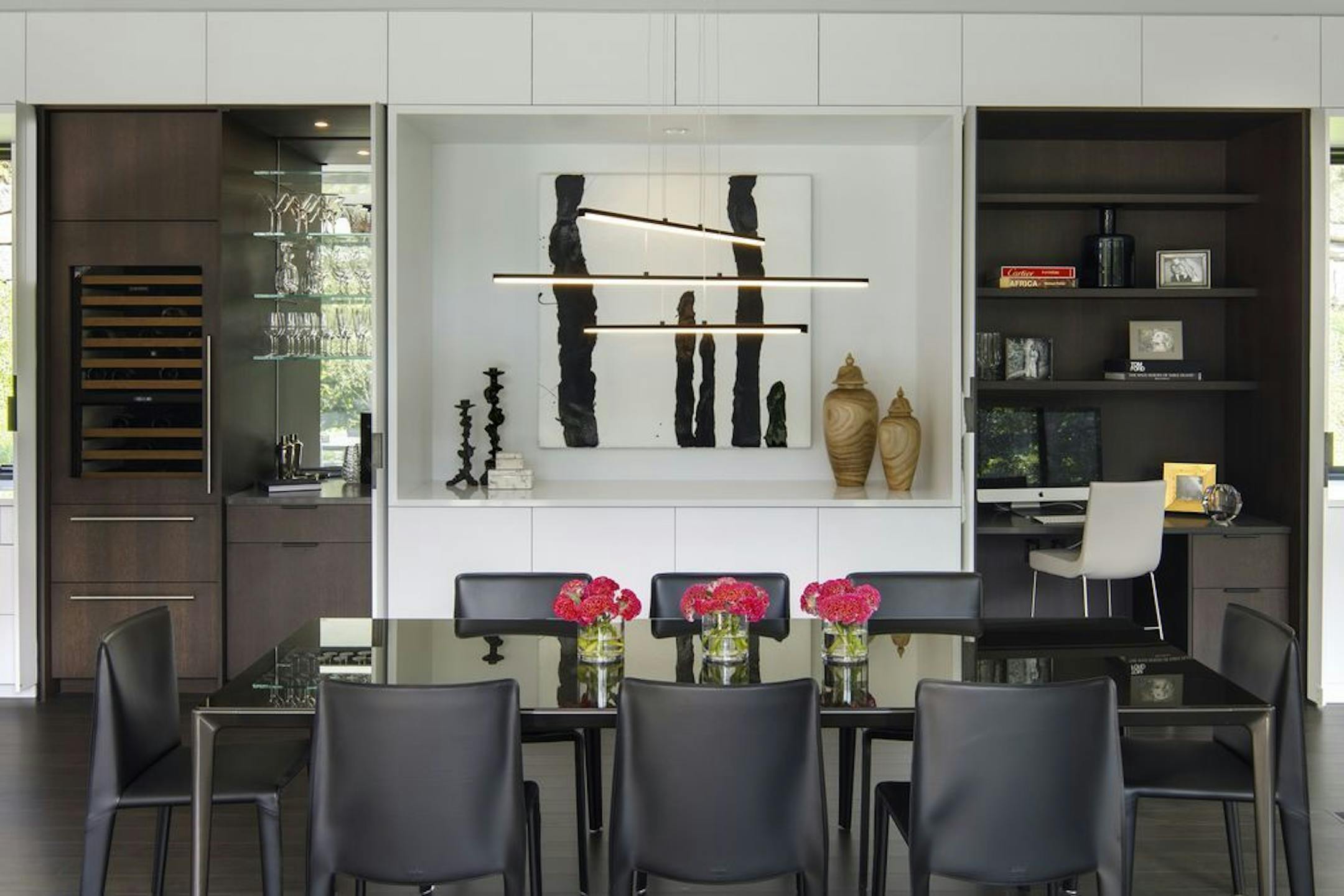 Pivoting pocket doors in the dining area open to reveal a beverage bar and office.