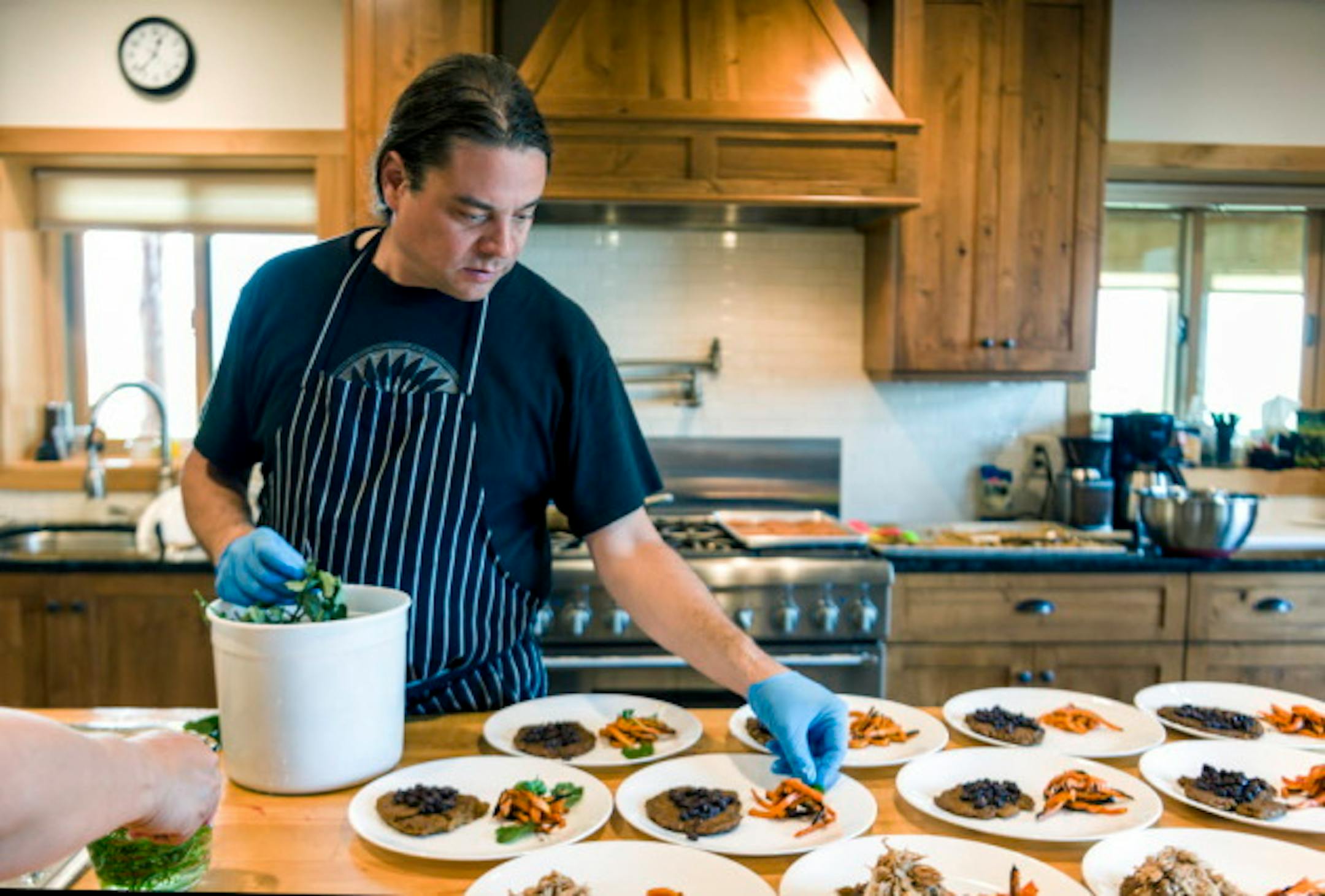 Chef Sean Sherman, who is Oglala Lakota and draws from the knowledge of the Lakota and Ojibwe tribes for his cooking, plating in the kitchen at Coteau des Prairies Lodge near Havana, N.D., July 19, 2016. Sherman's work is part of a slowly gathering movement that he and other cooks are calling 'new Native American cuisine,' or 'indigenous cuisine'-- an effort to revitalize native food cultures in contemporary kitchens. (Dan Koeck/The New York Times)