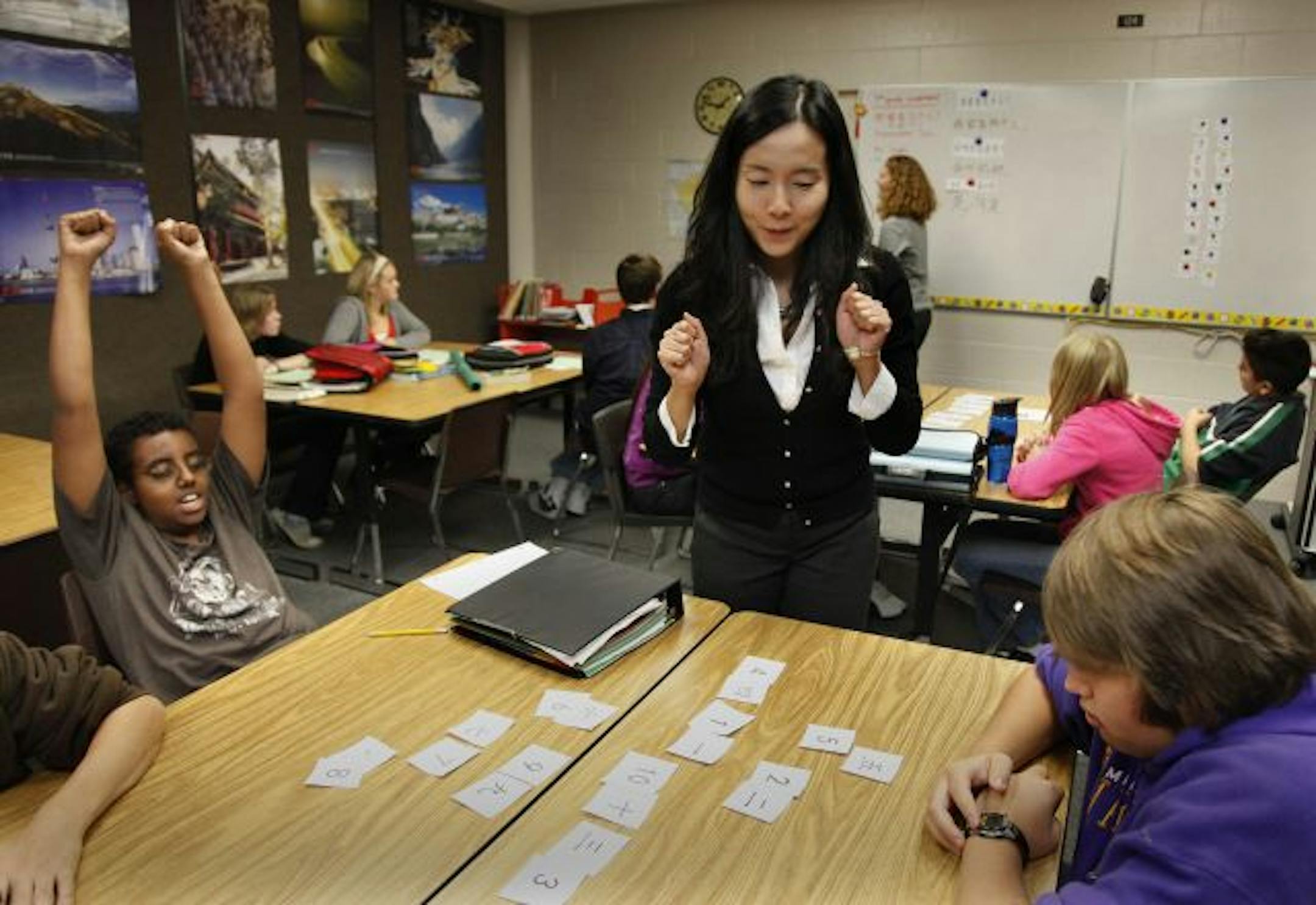 Xu Jia at Scott Highlands Middle School, Apple Valley, celebrates with Robel Wendweson, left after correctly matching numbers 1 through 10 during her class.
