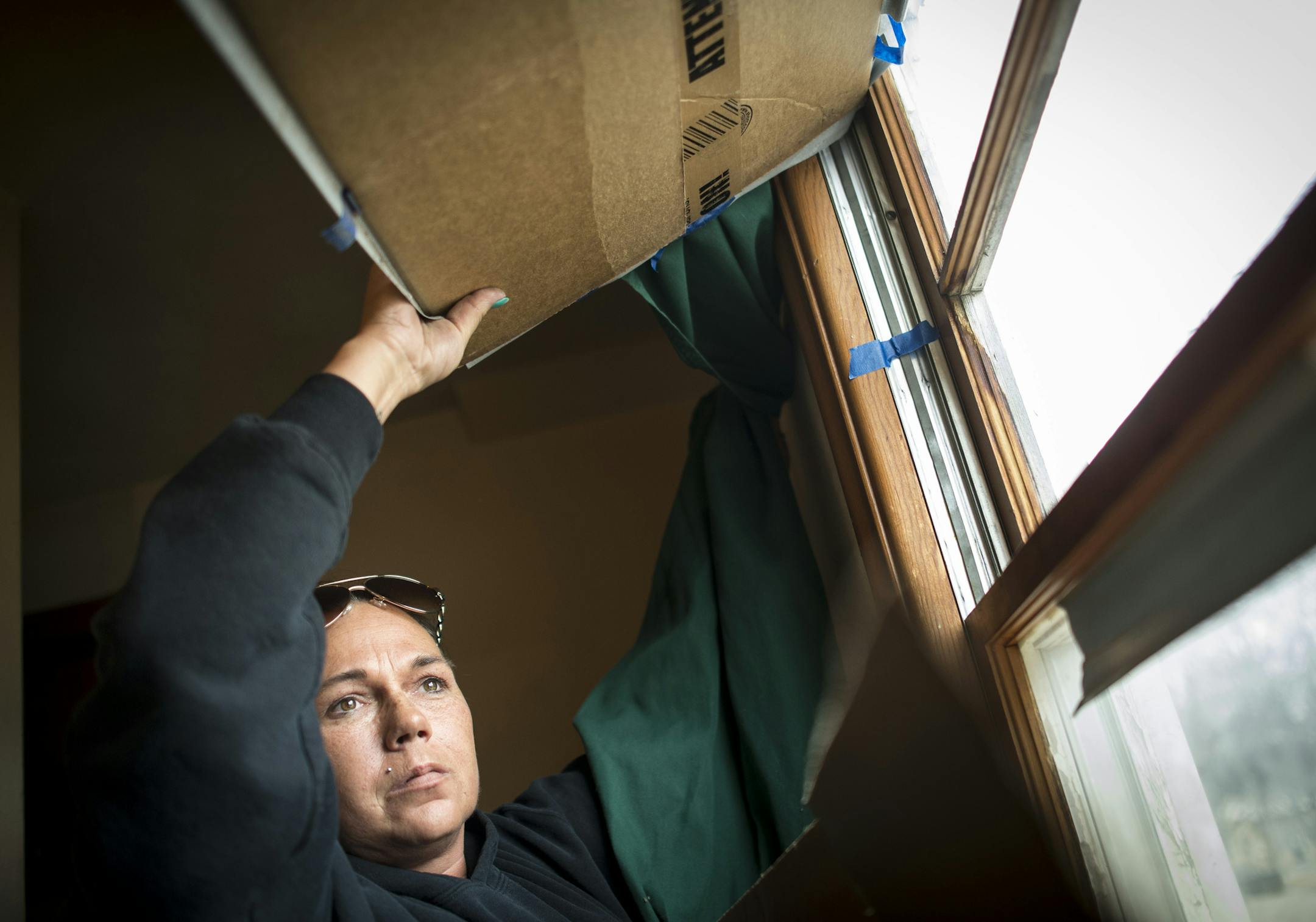 Lisa Snidarich pulls back a cardboard panel to reveal a broken upstairs window in her rental home owned by William Bernier. Many of the windows in the home are broken, some being hastily repaired with pieces of plexiglass being held into place with nails and screws. ] (Aaron Lavinsky | StarTribune) Lisa Snidarich needed a place to live, fast. She was getting divorced and has four kids. So when William Bernier said he would clean up a South St. Paul home, she believed him. Months later, Snidarich