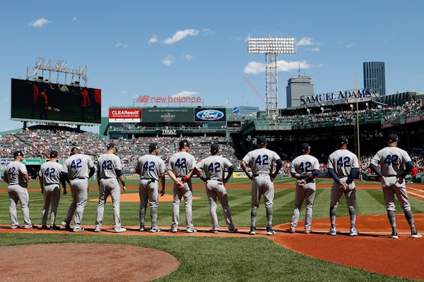 The Minnesota Twins line up on the base line before a baseball game against the Boston Red Sox, Friday, April 15, 2022, in Boston. (AP Photo/Michael D