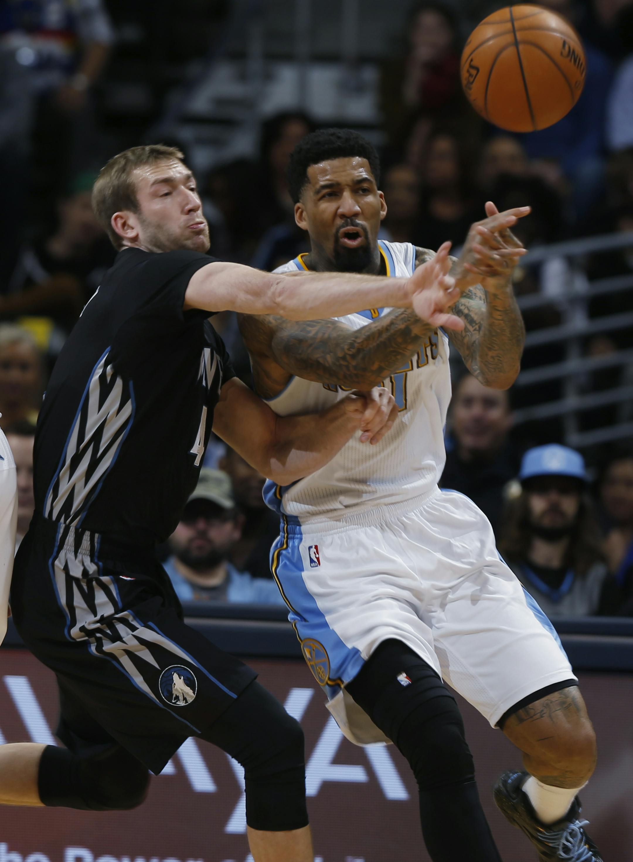 Minnesota Timberwolves forward Robbie Hummel, left, deflects pass for Denver Nuggets forward Wilson Chandler in the first quarter of an NBA basketball game Saturday, Jan. 17, 2015, in Denver. (AP Photo/David Zalubowski)