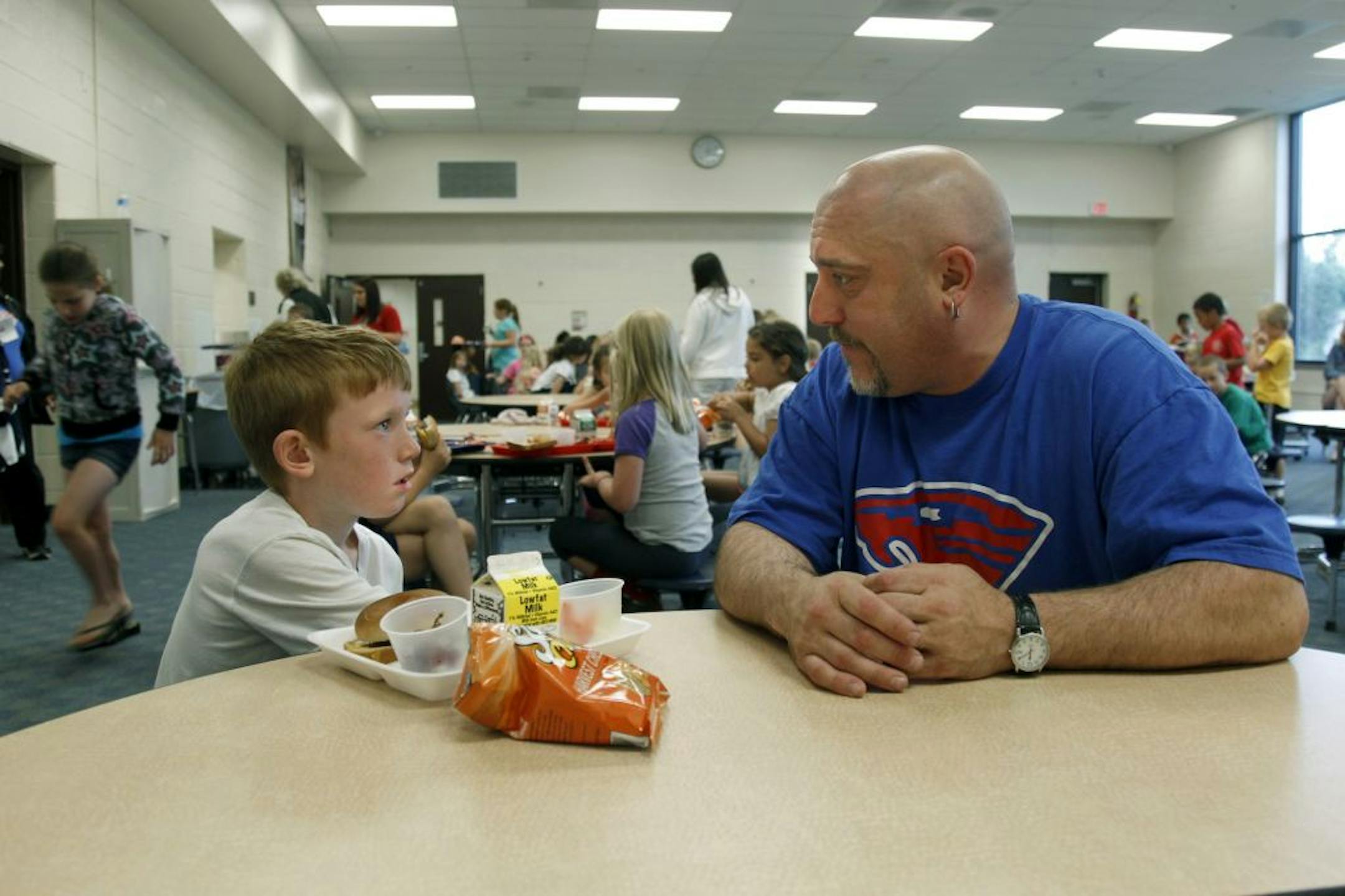 Joey Bergdahl of Blaine sat with his son Dewey, 8, for lunch at Woodcrest Ele­mentary Thursday. Bergdahl said the lunch program is superior to fast food.