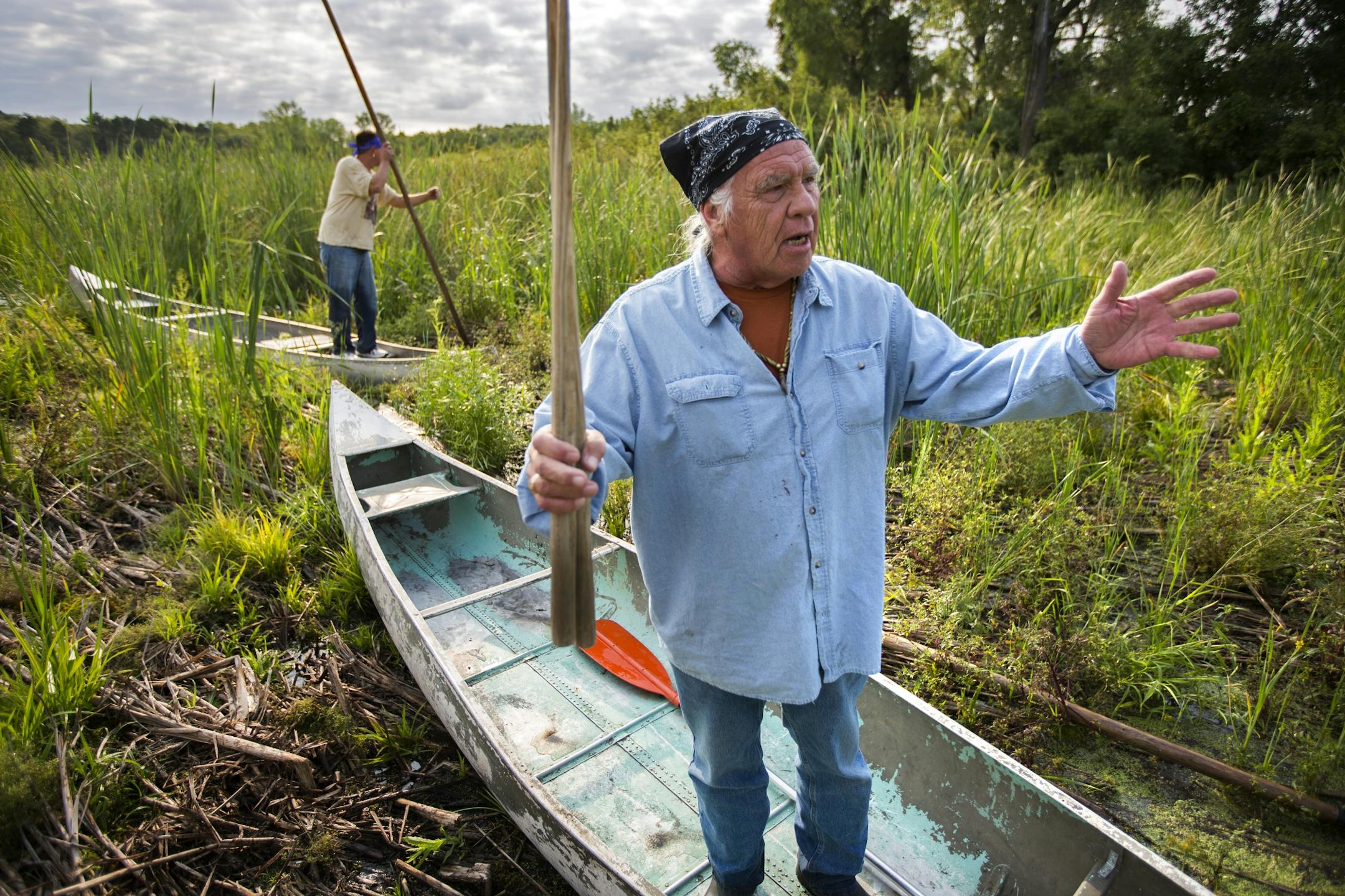 Leonard Thompson (front) and his son Todd speak to the gathered crowd before heading out into Hole In The Day Lake to harvest wild rice Thursday morning.