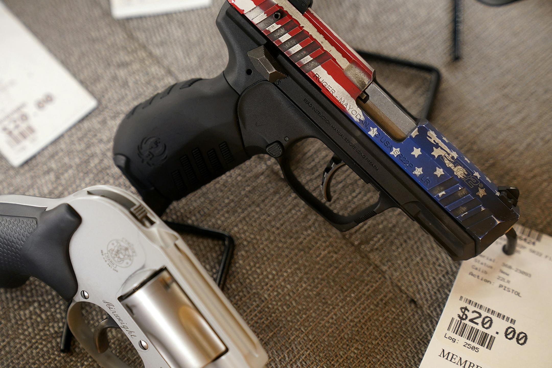 Handguns to use on the shooting range, including this patriotic Ruger SR22, behind glass in cases for rent at the Stock & Barrel Gun Club.