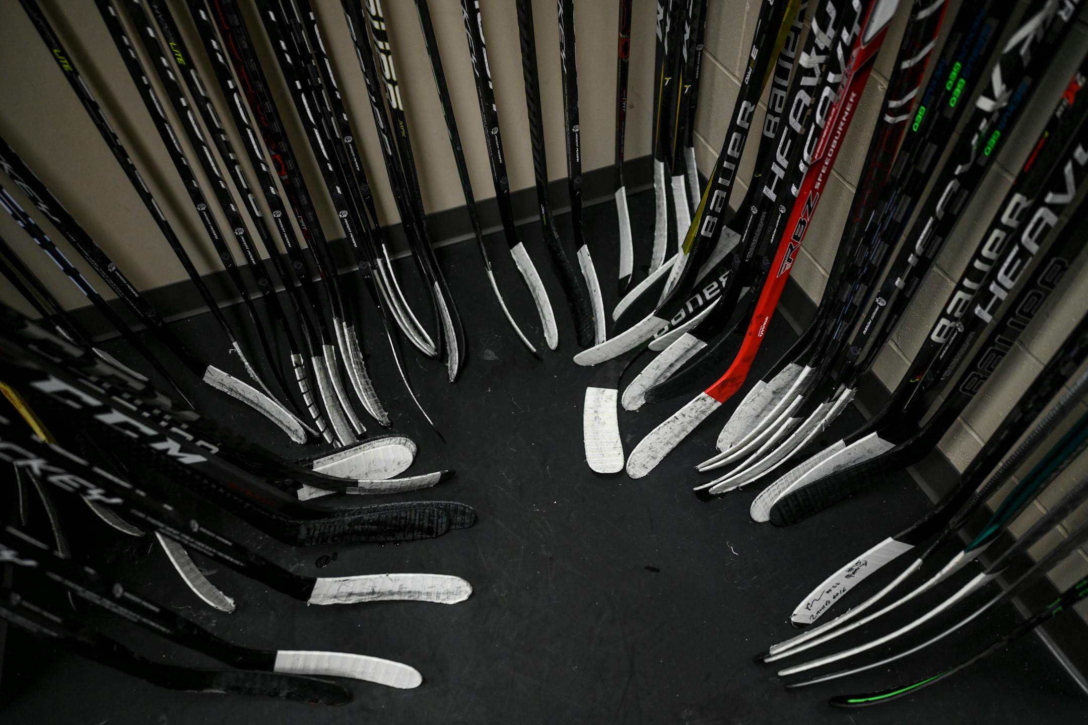 Hockey sticks rest up against the wall near the entrance to Rock Ridge's locker room Tuesday, Feb. 22, 2022 at the Iron Trail Motors Event Center in Virginia, Minn.