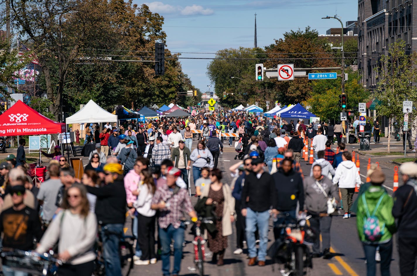 Hundreds of people walk past vendors during Open Streets Minneapolis.