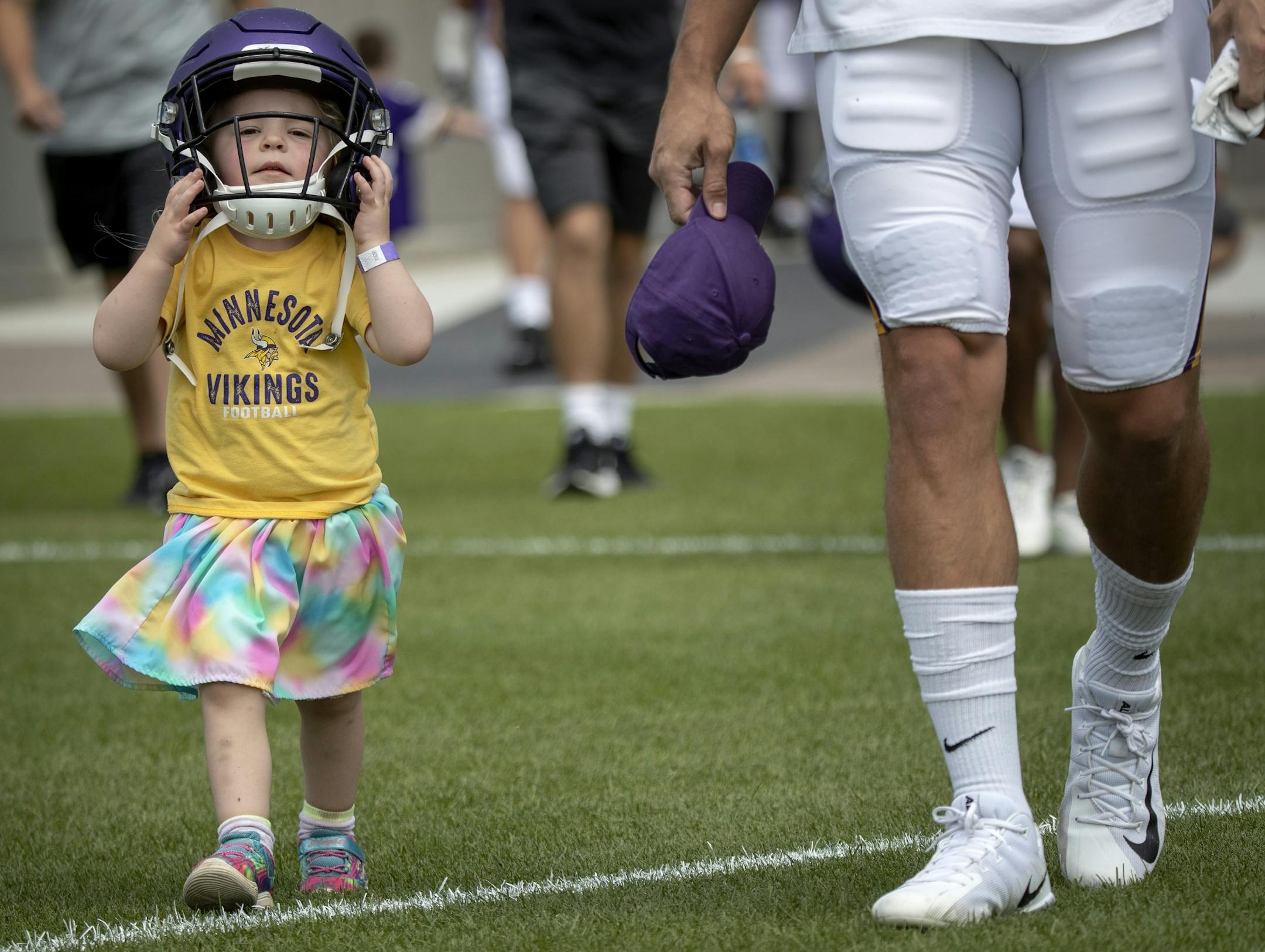 Maria Rekow, 3, of St. Paul, walked out to the practice field wearing the helmet of Minnesota Vikings' Cole Hikutini.