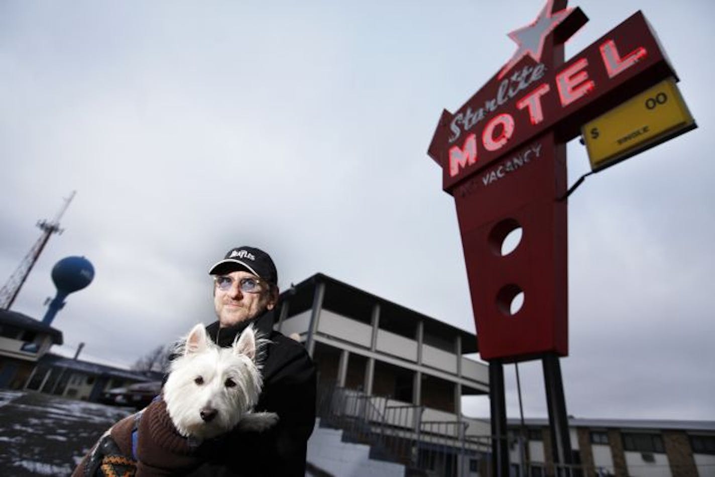 Tom Brezny has been the manager of the Starlite Motel in Hilltop for about 14 months. Brezny describes the place as an "inner city, blue-collar motel. It can be rough at times." He is pictured with his office dog, Addie, 2. The village has the somewhat-embarrassing distinction of leading the state in crimes per person.