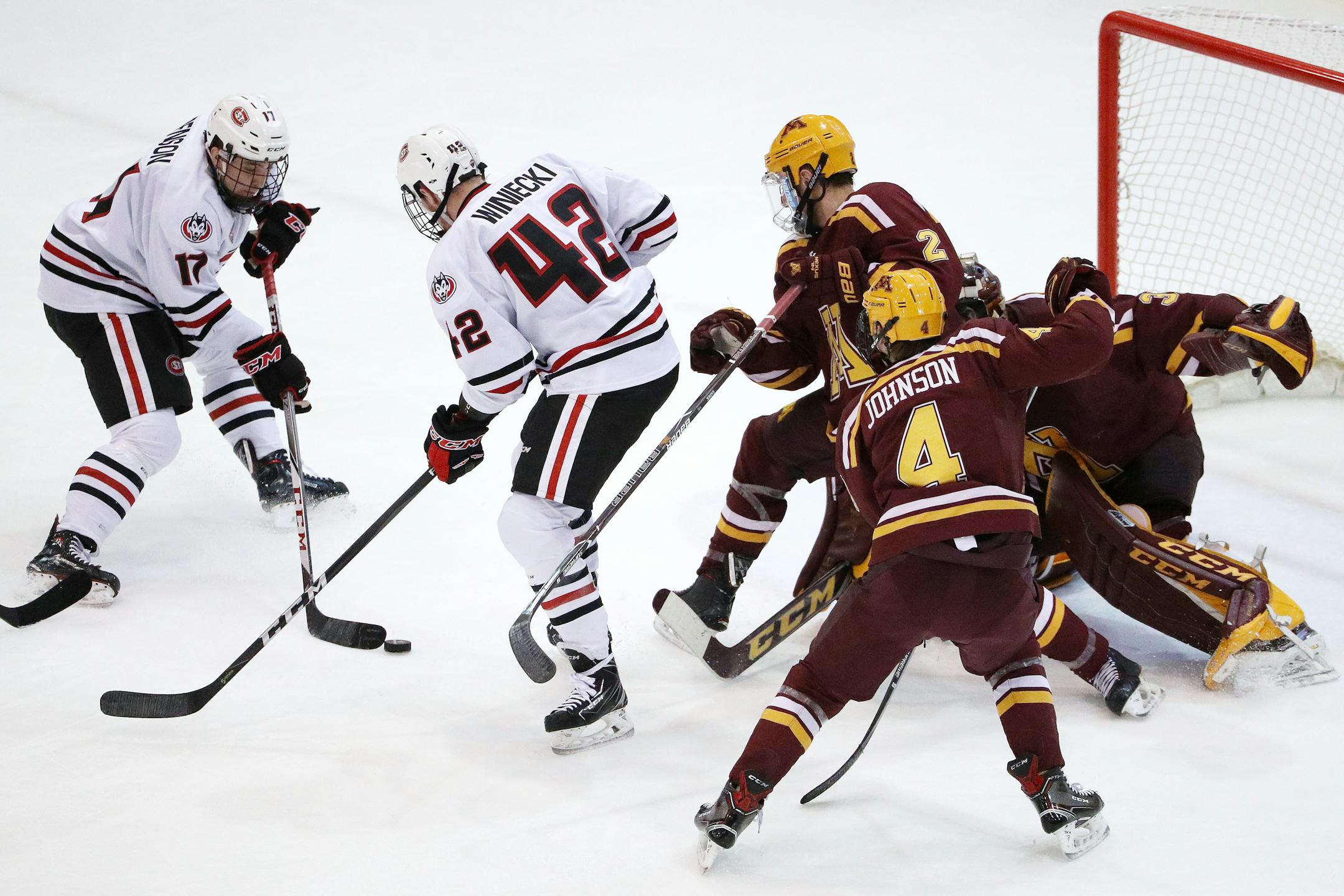 St. Cloud State forwards Jacob Benson (17) and Blake Winiecki (42) tried to get the puck past Minnesota goaltender Eric Schierhorn