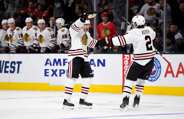FILE - In this Nov. 28, 2015, file photo, Chicago Blackhawks right wing Patrick Kane, left, celebrates his goal with defenseman Duncan Keith during th