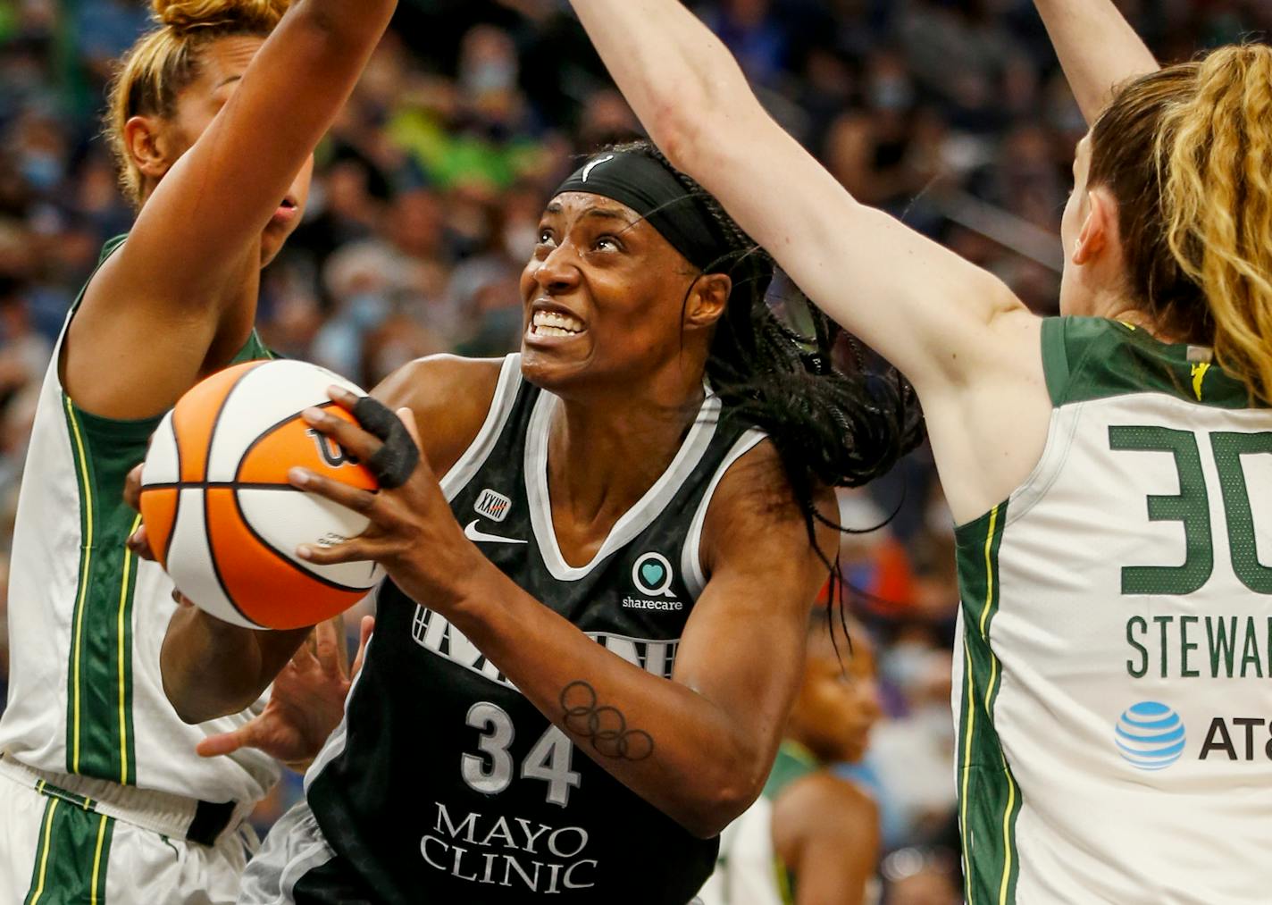 Minnesota Lynx center Sylvia Fowles (34) goes to the basket between Seattle Storm center Mercedes Russell and forward Breanna Stewart (30) in the second quarter of a WNBA basketball game Tuesday, Aug. 24, 2021, in Minneapolis. (AP Photo/)