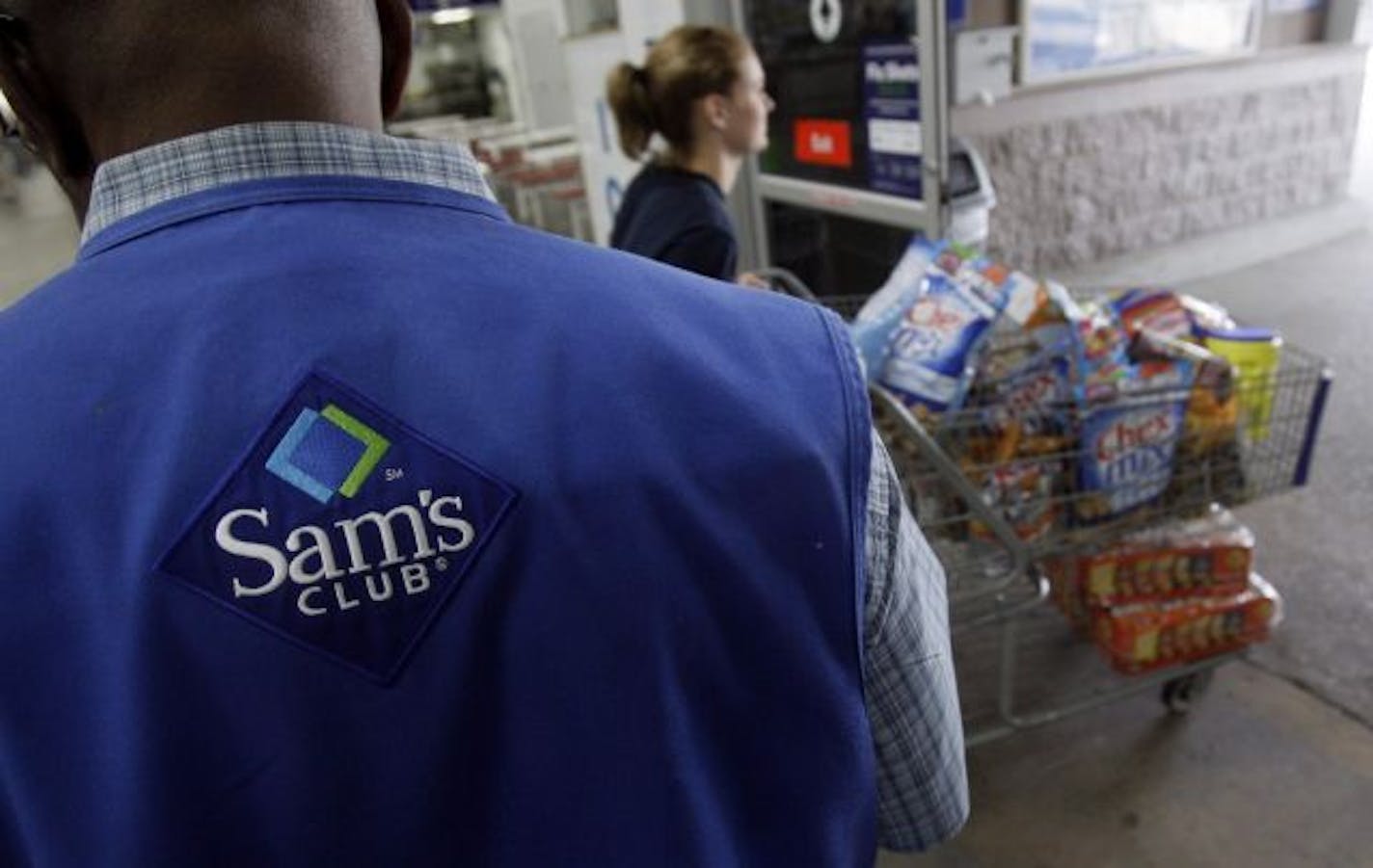 A store associate watches as a customer leaves with her purchases at Sam's Club in Jackson, Miss., Thursday, Sept. 9, 2010. Inventories held by wholesalers surged in July by the largest amount in two years while sales rebounded after two straight declines.