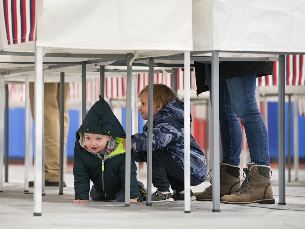 Cooper Stinson, 3, center, kept an eye on his younger brother Coen, 2, as their mom Kelly Stinson voted in the New Hampshire primary Tuesday.