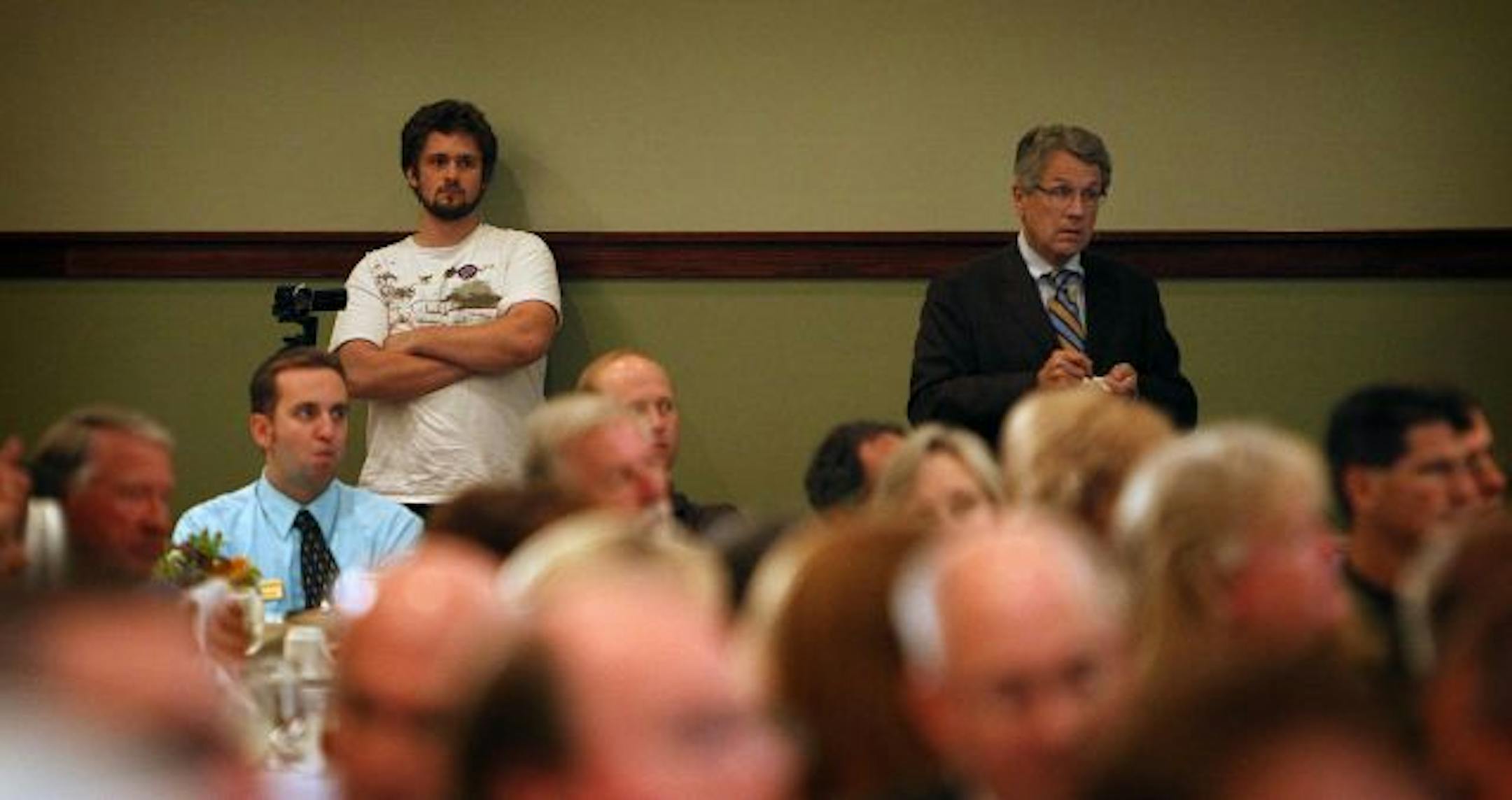 DFL tracker Colin Clark, with the Independence Party's Tom Horner at right, waited for the start of Tuesday's debate. Trackers from both parties have been mocked, criticized and likened to terrorists.