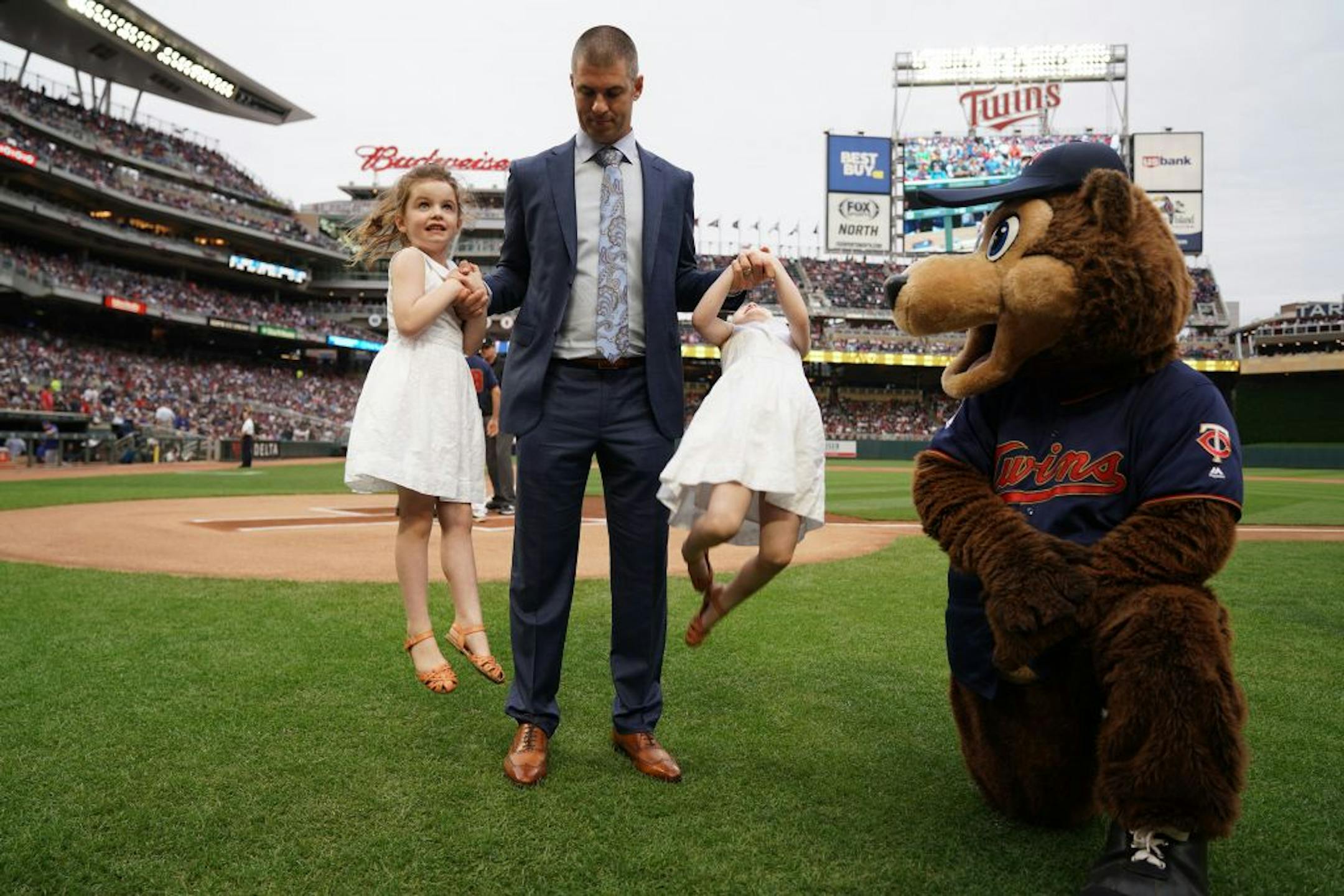 Former Minnesota Twins star Joe Mauer hoisted up his twin girls as they stood on the field following a pregame ceremony to retire his number 7 Saturday.