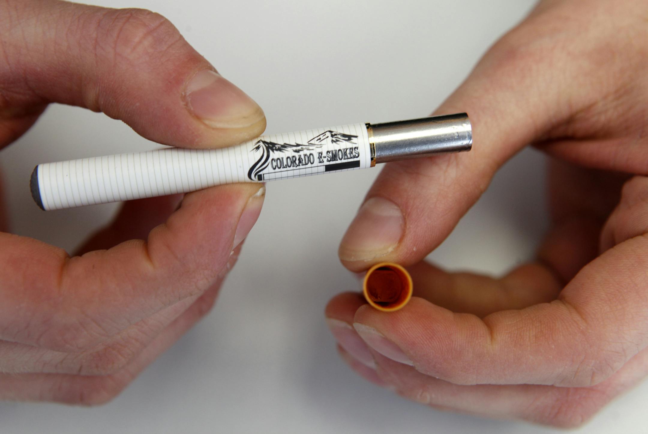 FILE - In this March 2, 2011, file photo, a clerk holds an electronic cigarette and the filter end that holds the liquid nicotine solution at an E-Smokes store in Aurora, Colo. Increasingly popular e-cigarettes and cigar varieties could be exempt from some government safety regulations if House Republicans have their way. It's a move that alarms Democrats and public health advocates who argue that it could lead to unsafe products. (AP Photo/Ed Andrieski, File) ORG XMIT: WX201