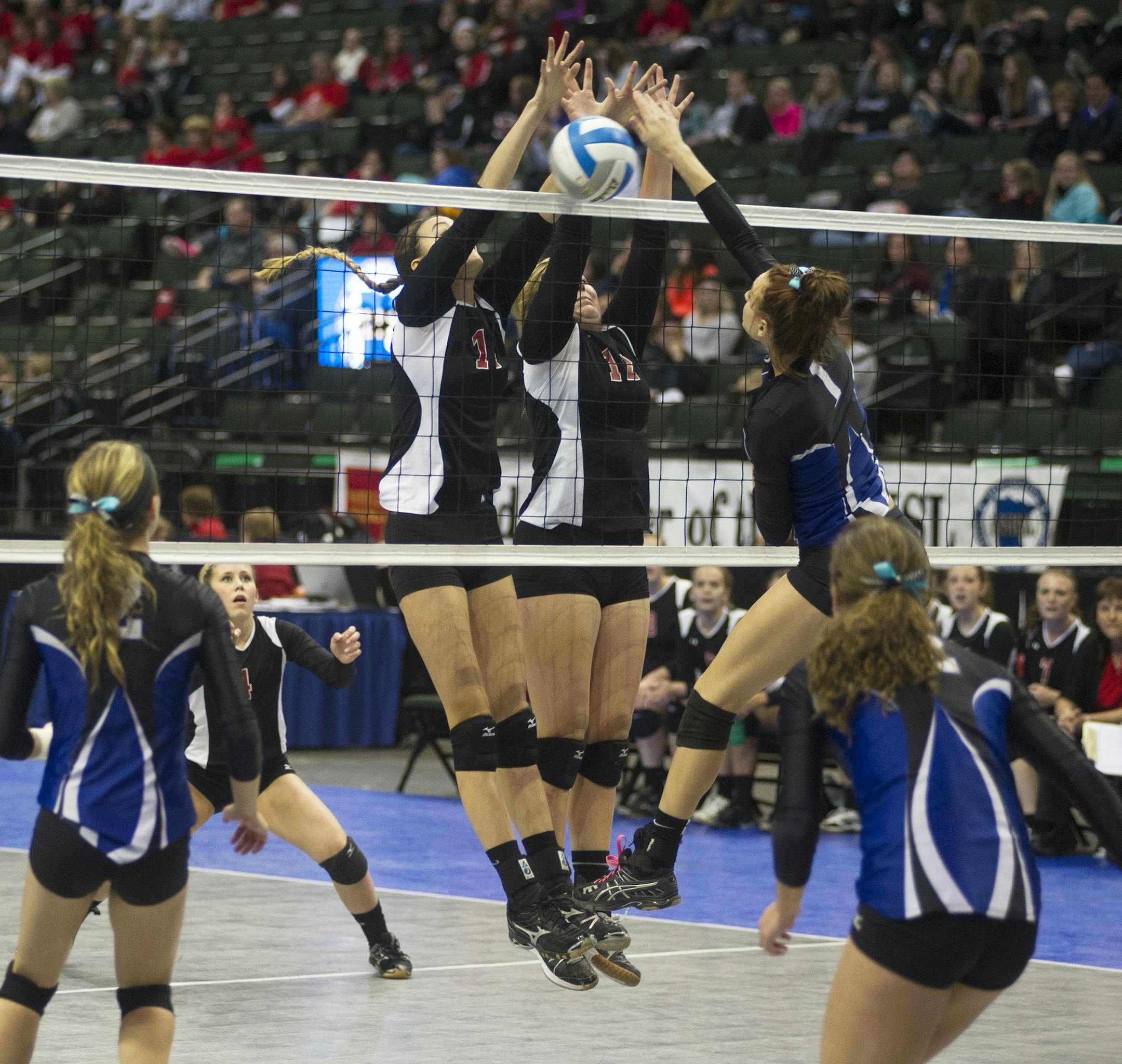 Martin County West, Sherburn's Hailey Leiding puts one up against Ada-Borup's Morgan Miller, left, and Lexi Merkens during the Class 3A girls' volleyball state quarterfinals, Thursday, November 6th, 2014 at the Xcel Energy Center in St. Paul, MN. Martin County West, Sherburn won in four sets. ] (Matthew Hintz, 110714, St. Paul)