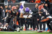 Minnesota Vikings tight end T.J. Hockenson (87) went airborne picking up a first down over Cincinnati Bengals safety Dax Hill (23) in the fourth quart