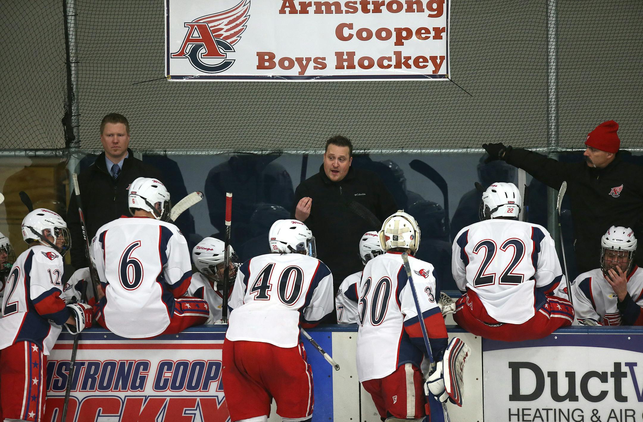 The Armstrong/Cooper team known as the Wings, showcasing red on its jerseys for Armstrong and blue for Cooper, listened to coaches during a timeout.
