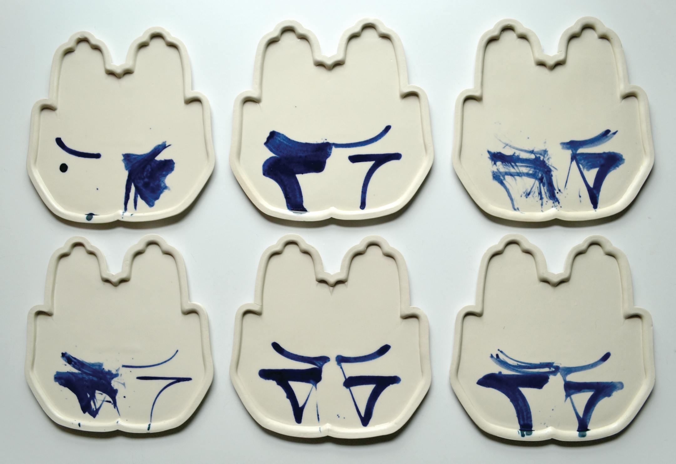 Adam Chau's "Palm Plates" represent the shape of the human hand, decorated with calligraphic brush strokes. (Provided by Northern Clay Center)