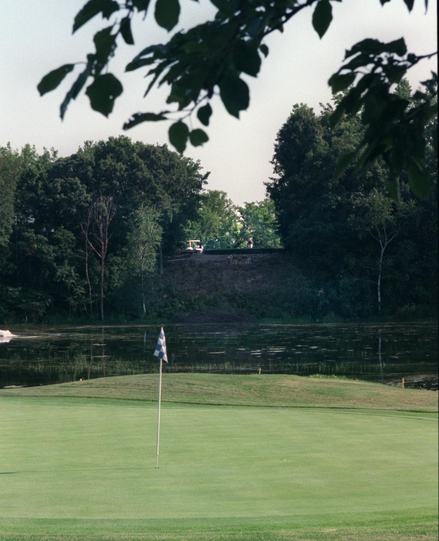 GENERAL INFORMATION: STILLWATER, MN - THUR - 8/10/2000 - Fifth Hole at Sawmill, a 202-yard par-3, for the hole of the week. The shot should be taken from the back of the green, looking up at the tee box on the shooter's right. The shot includes the flagstick, as well as the lake that golfers have to carry to reach the green. Member Julio Barron stood atop the tee and contemplated the situation. IN THIS PHOTO: The shot includes the flagstick, as well as the lake that golfers have to carry to reac