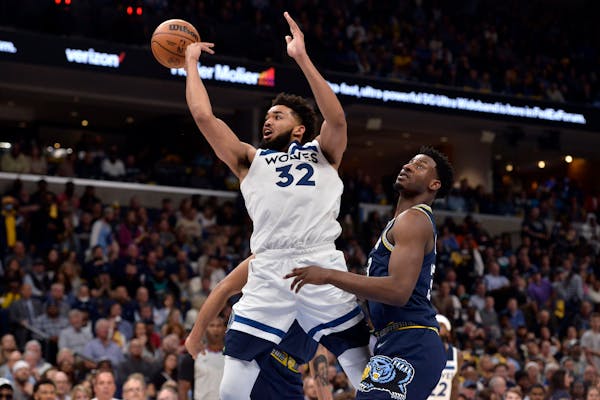 Timberwolves center Karl-Anthony Towns passes the ball away from Memphis forward Jaren Jackson Jr. during the second half of Game 2