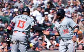 The Twins' Carlos Santana is greeted by Manuel Margot after crossing home plate in the 11th inning during the first game of a doubleheader Saturday in