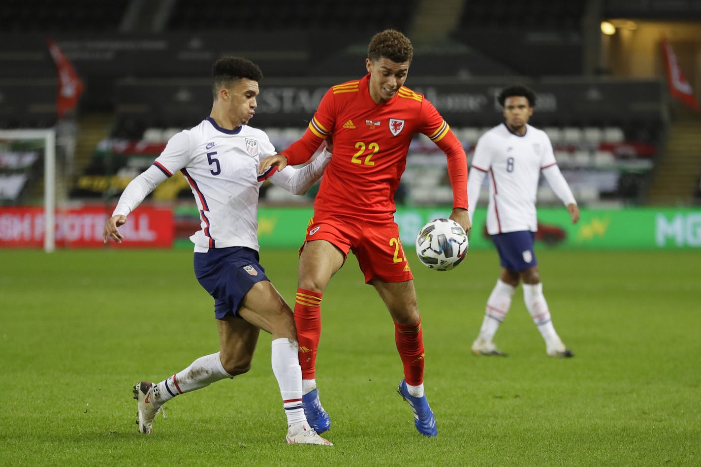 United States' Antonee Robinson vies for the ball with Wales' Brennan Johnson during the international friendly soccer match between Wales and USA at Liberty stadium in Swansea, Wales Thursday, Nov. 12, 2020. (AP Photo/Kirsty Wigglesworth)