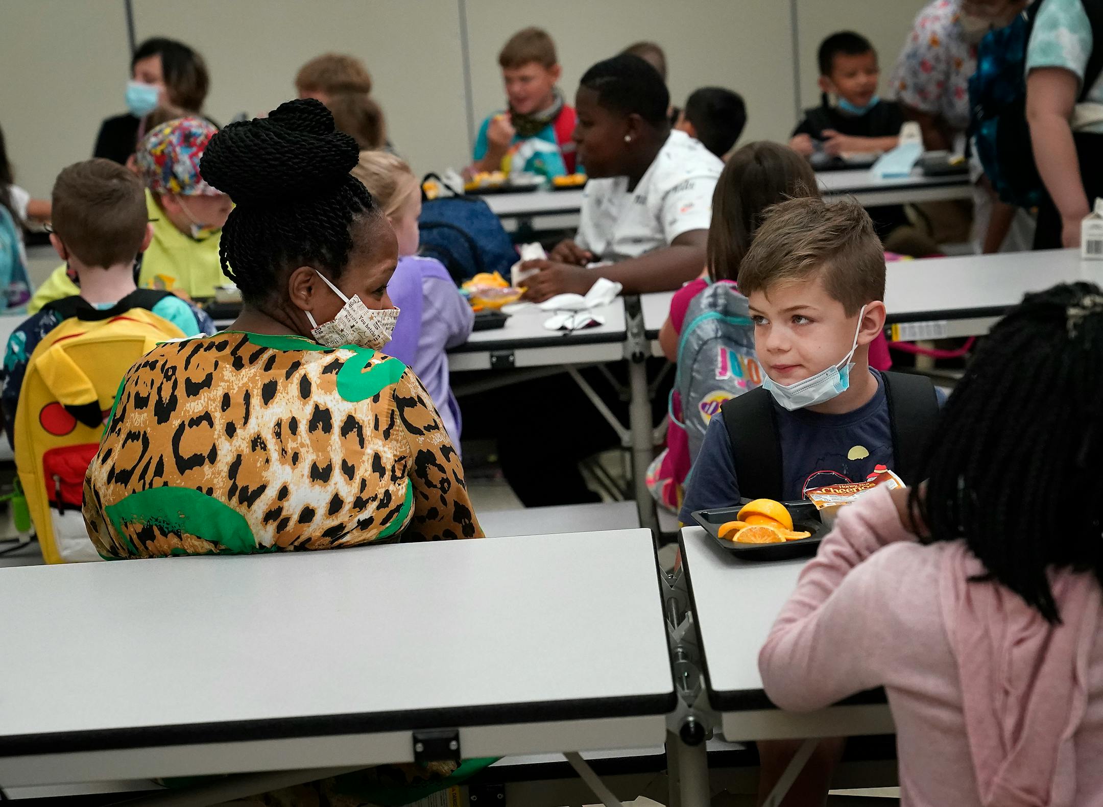 New Hoover Elementary School principal Keisha Davis chatted with first grader Zayne Carlson who ate breakfast before the start of the first day of school Tuesday in Coon Rapids.   ]