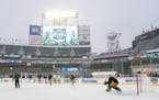 Minnesota Wild right wing Brandon Duhaime (21) takes a shot on goalkeeper Cam Talbot (33) during outdoors practice as a light snow falls at Target Fie