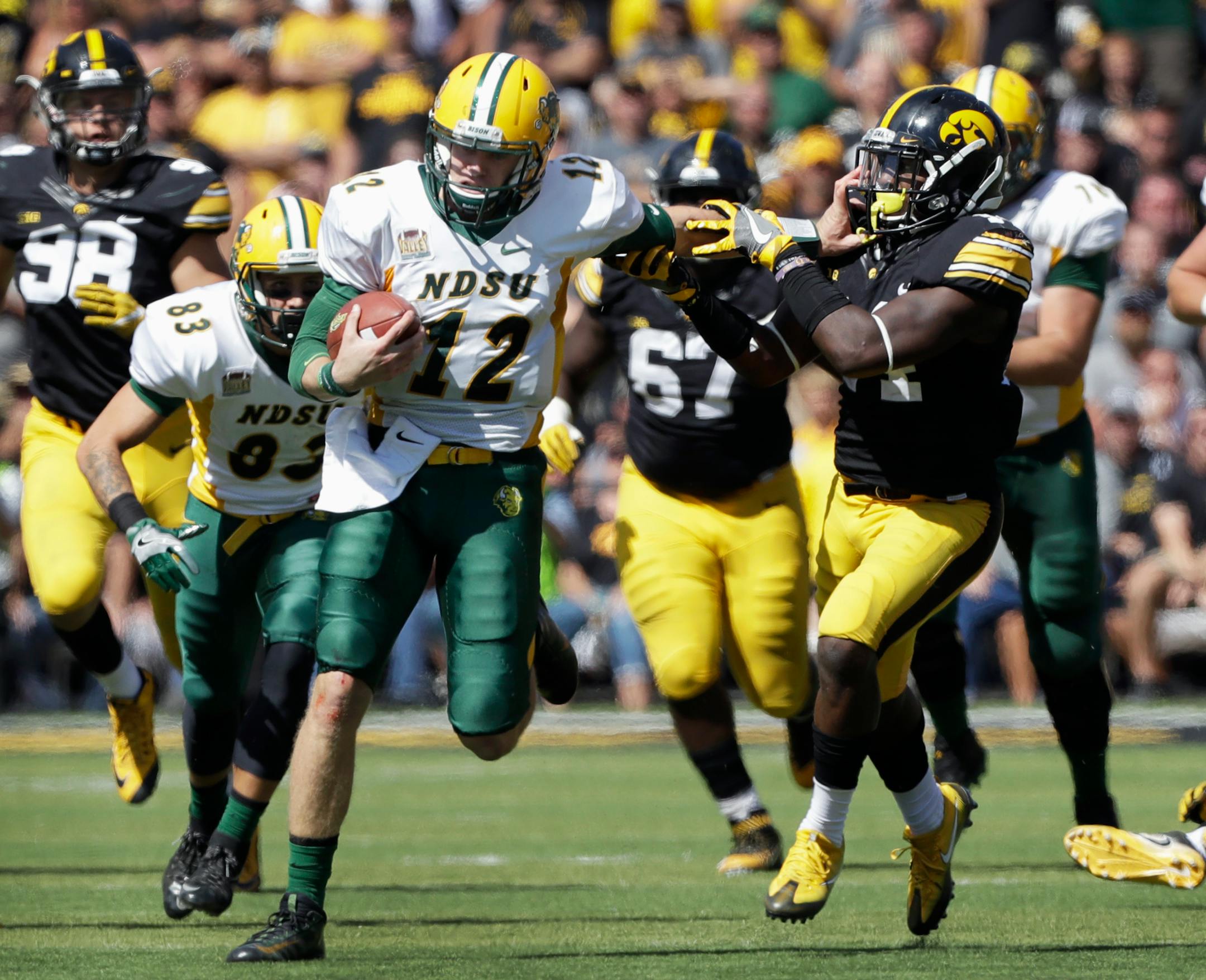 North Dakota State quarterback Easton Stick (12) tries to break a tackle by Iowa's Desmond King during an NCAA college football game in Iowa City, Iowa. North Dakota State won 23-21.