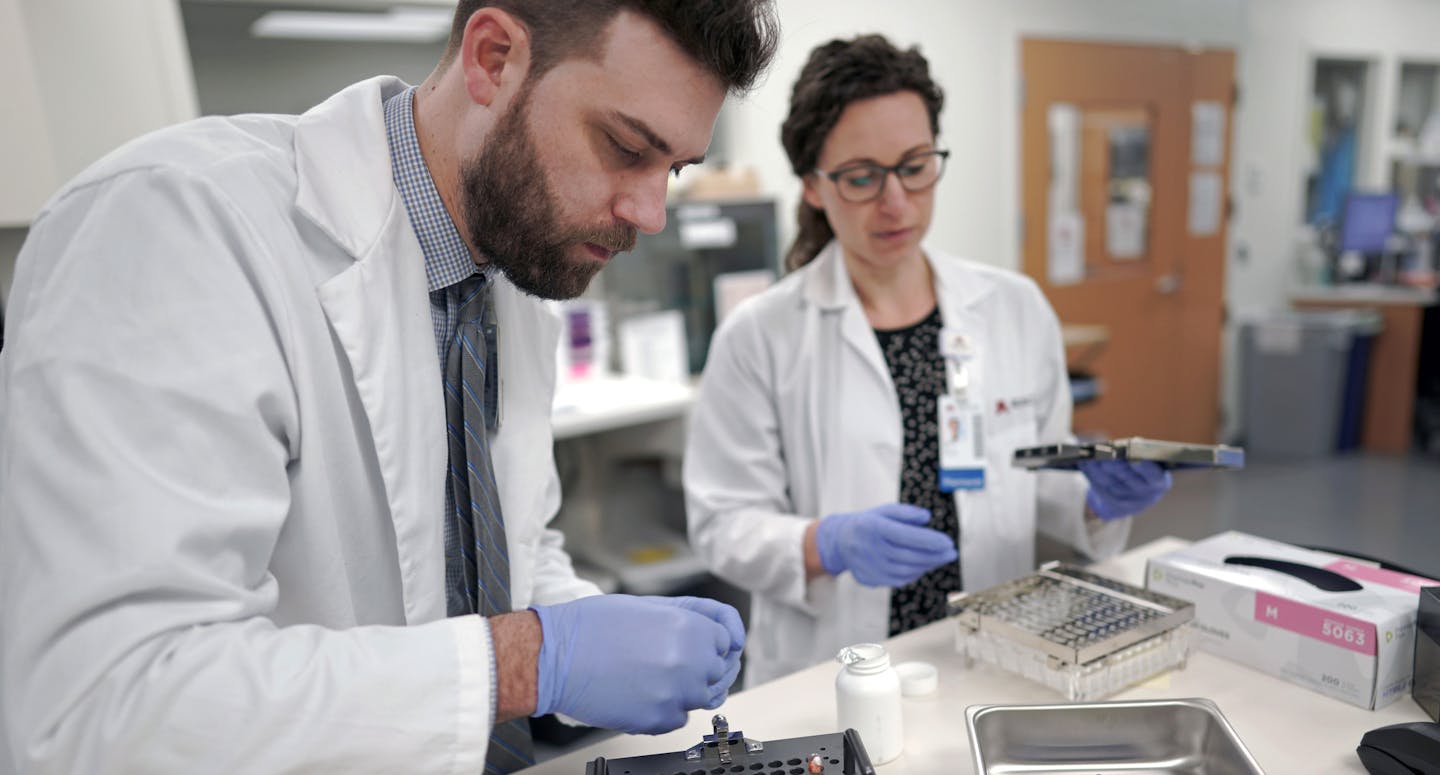 Fairview Health pharmacists Brett Benfield and Kelsey Larsen prepared capsules with both medication and digital sensors.