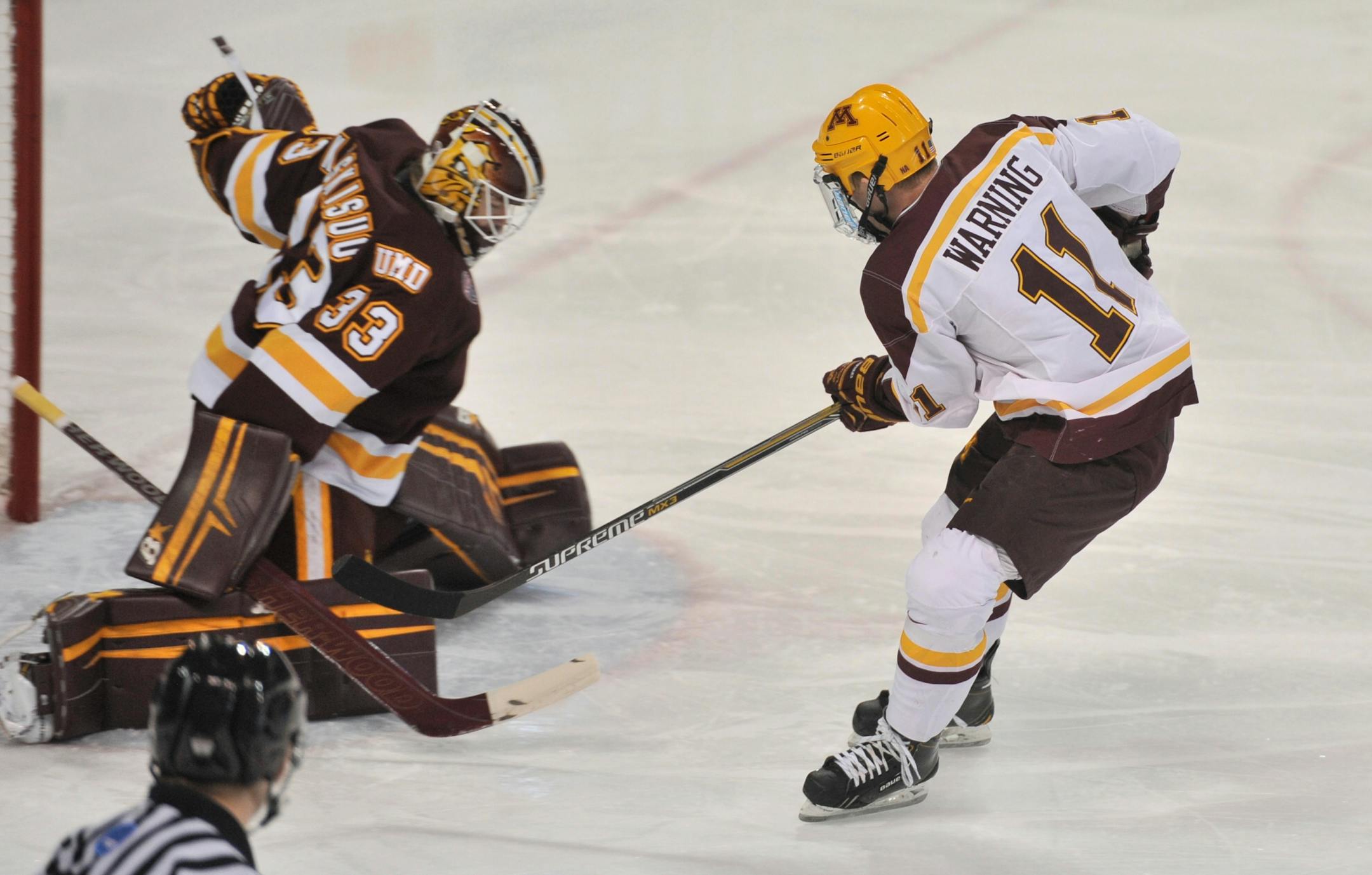 Minnesota left wing Sam Warning puts a shot up for a goal past Minnesota Duluth goalie Kasimir Kaskisuo during action in the Minnesota Minnesota Duluth college hockey game in the Ice Breakers Tournament Friday, Oct. 10, 2014 in South Bend, Ind.