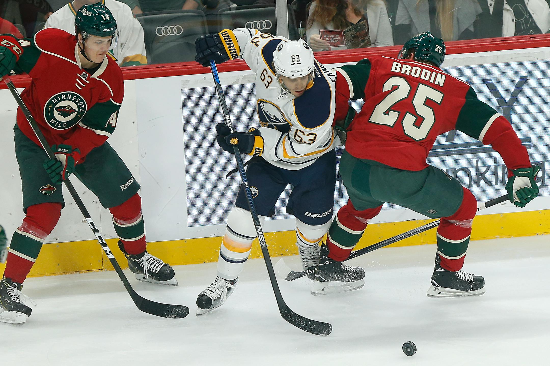Buffalo Sabres' Tyler Ennis tries to gain control of the puck against Minnesota Wild's Joel Eriksson Ek, left, and Jonas Brodin, right, in the first period of an NHL hockey game Tuesday, Nov. 1, 2016, in St. Paul, Minn. (AP Photo/Stacy Bengs)