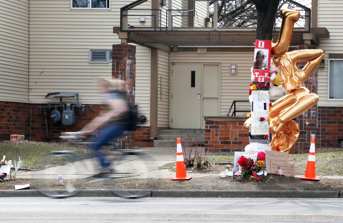 A day after Hennepin County attorney Mike Freeman announced his decision not to charge two police officers in the shooting of Jamar Clark, a bicyclist pedals by the Clark memorial site on Plymouth Ave. N. in Minneapolis.