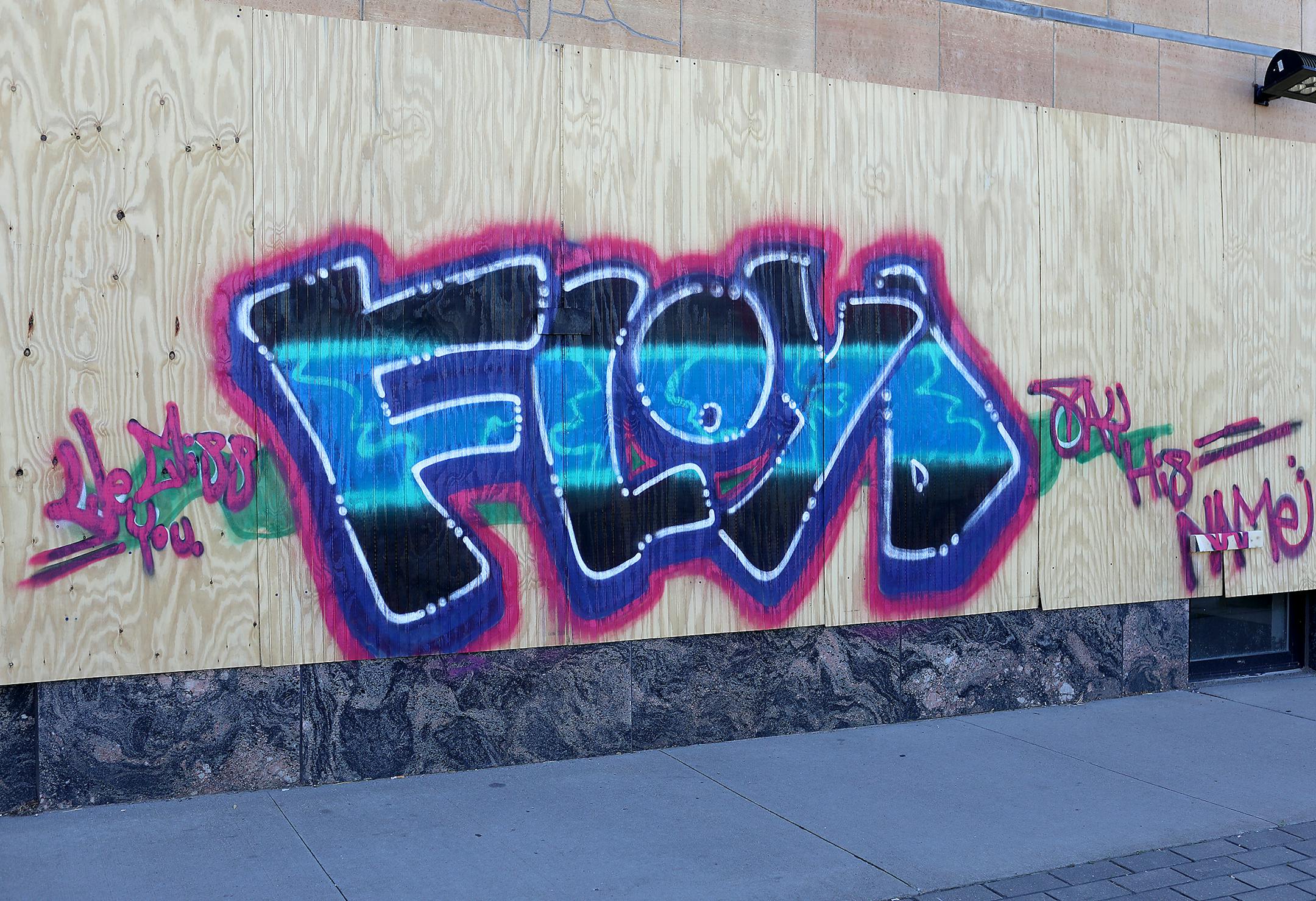 Street artists commemorate George Floyd by tagging his name outside of Caffe Biaggio at 2356 University Ave. W. in St. Paul.