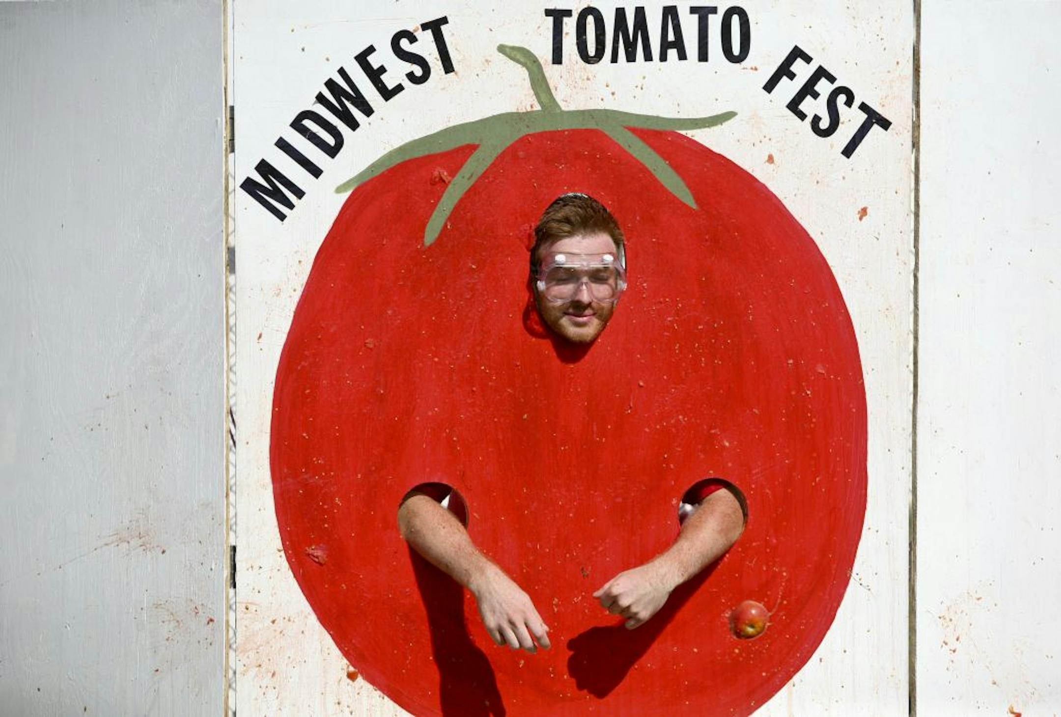 Kevin Walker, staff of Midwest Tomato Fest, watch a tomato miss him at SoundTown in Somerset Wis., Friday, August 19, 2011. As a promotion for the Fest passersby can pay money to try and hit Kevin in the face with tomatoes