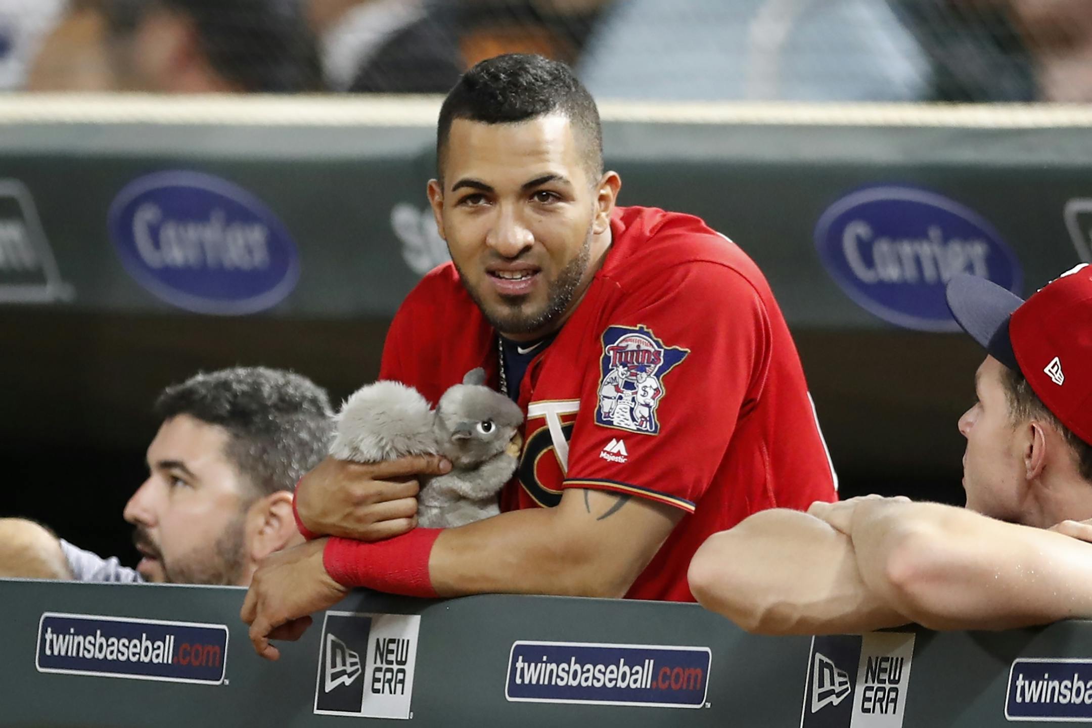 Eddie Rosario (20) holds the Twins' "rally squirrel" during the tenth inning.